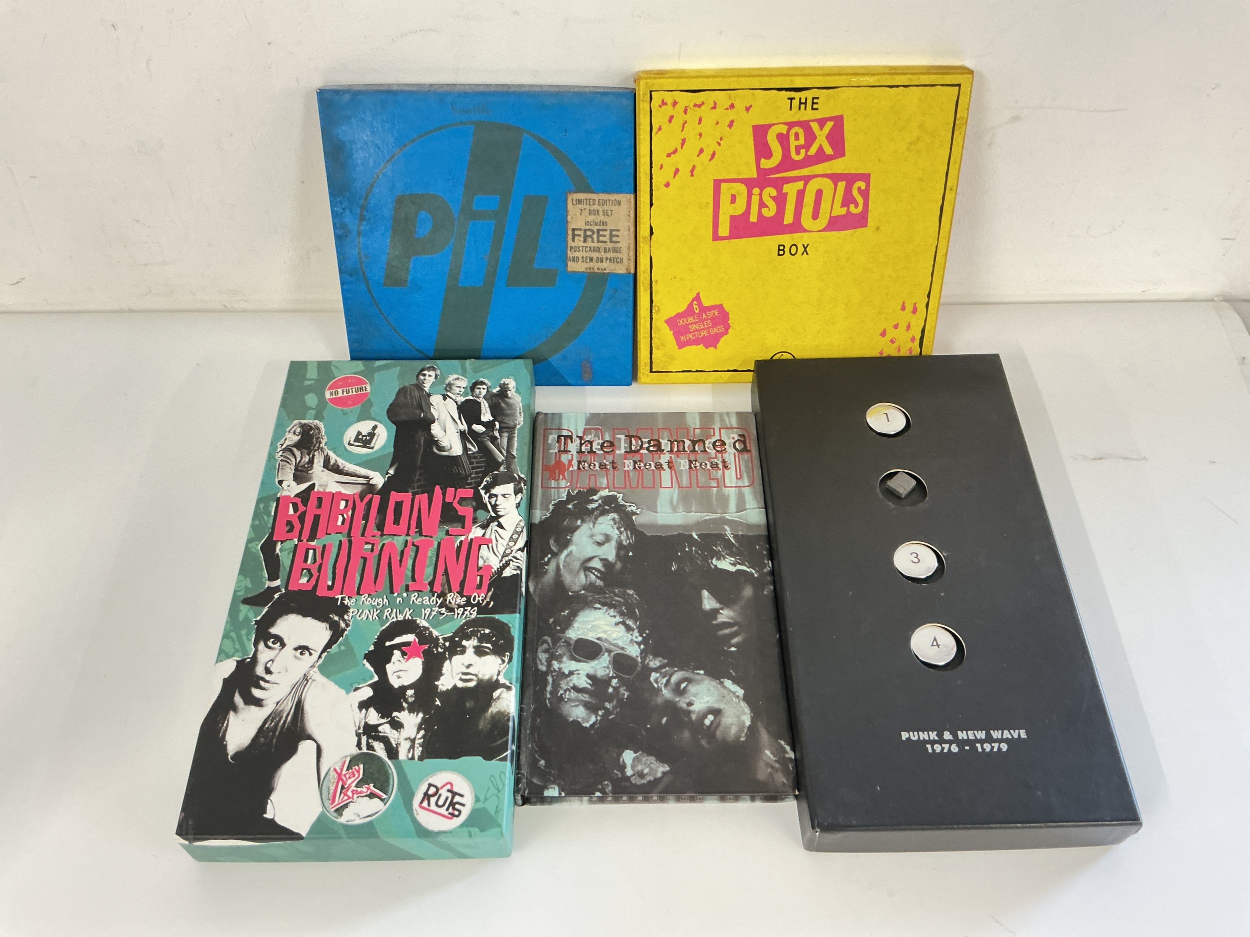 Five punk CD and vinyl box sets comprising a Sex Pistols x6 double A side singles box set, Babylon's Burning by The Clash, a Punk & New Wave compilation and releases by PiL and The Damned.