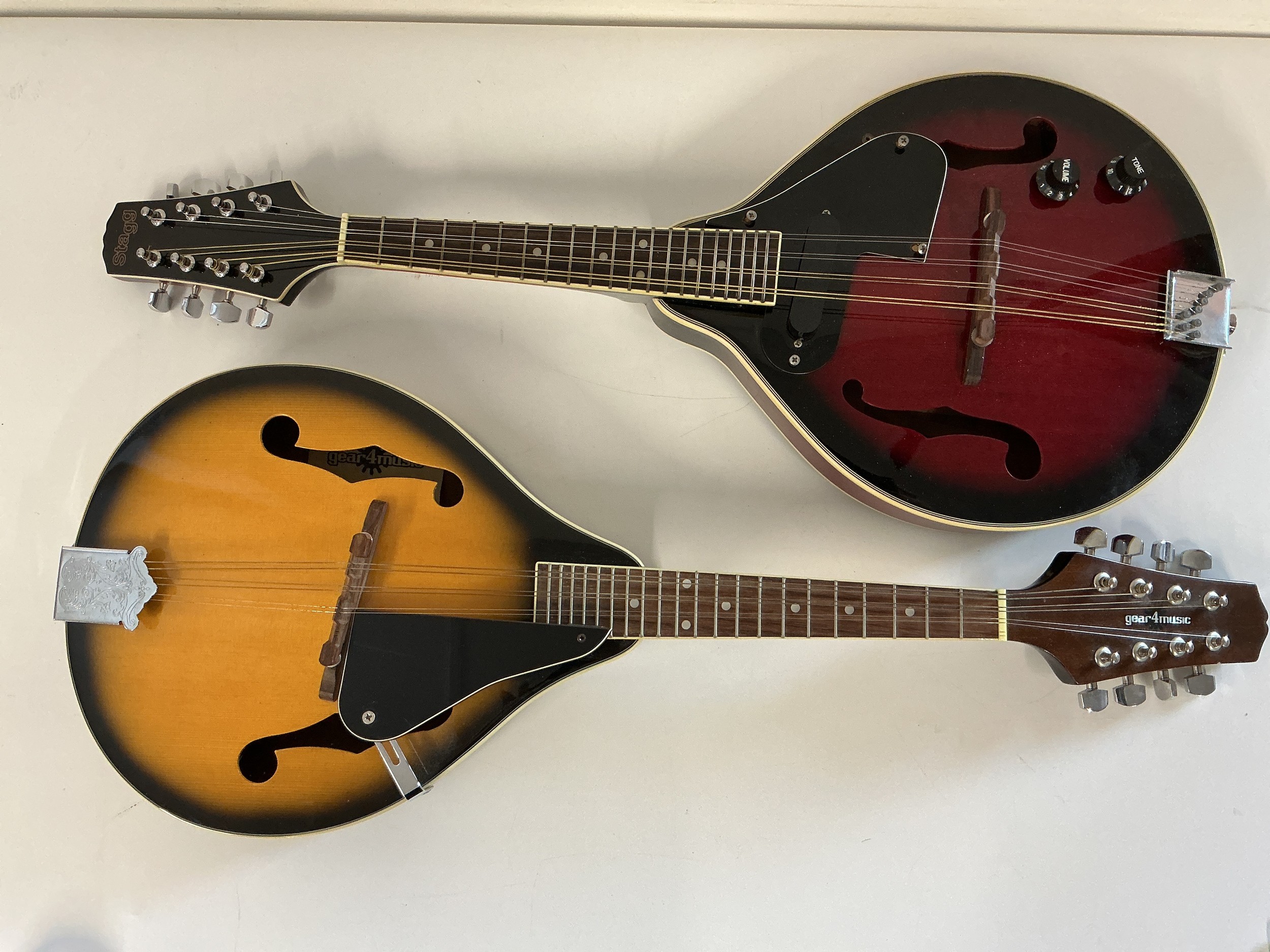 Two modern mandolins comprising a Stagg and a Gear 4 Music model, both with cases.