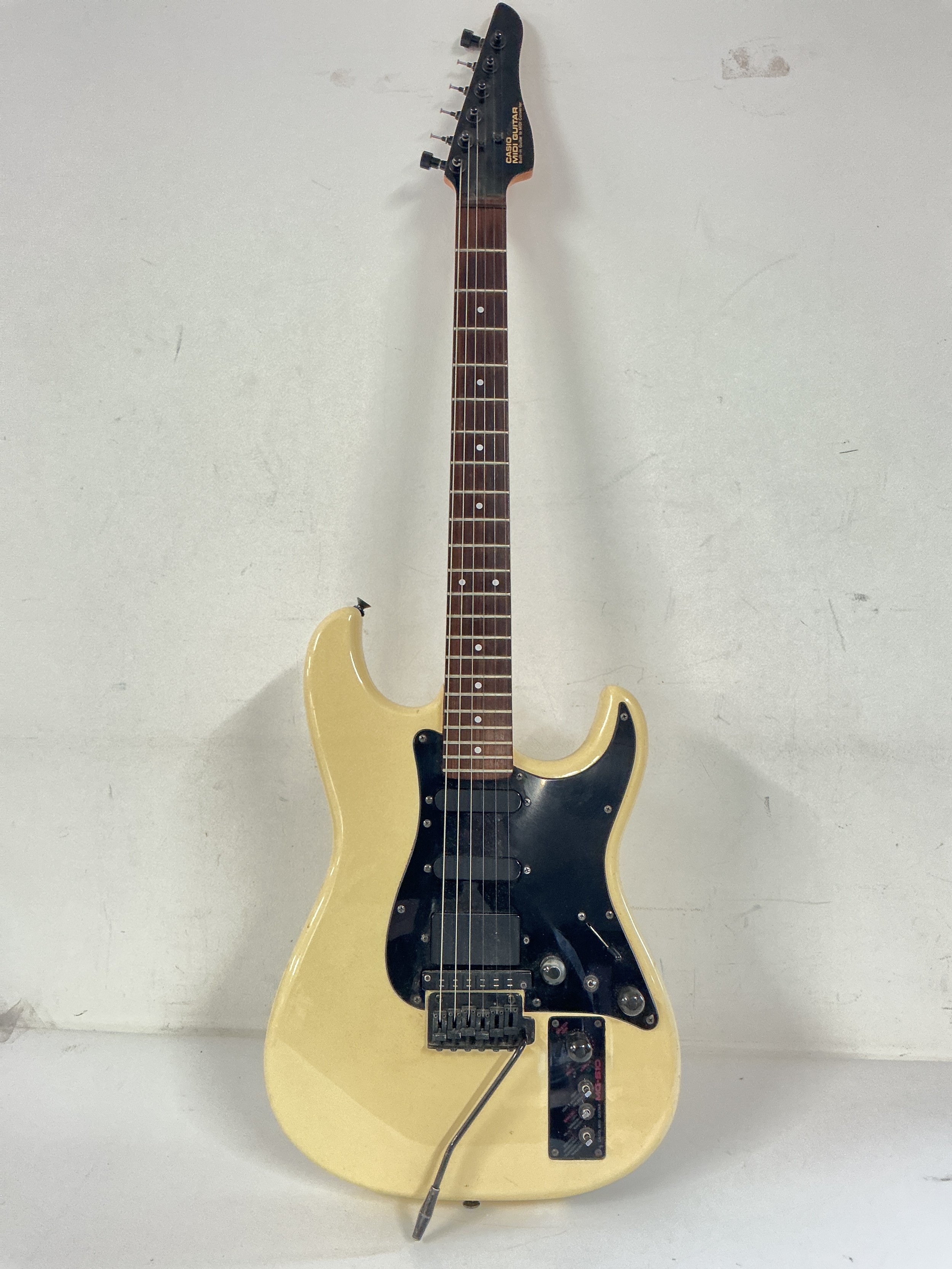 A Casio Midi MG-510 electric guitar. Needs new tuning pegs. Comes with a hard carry case.