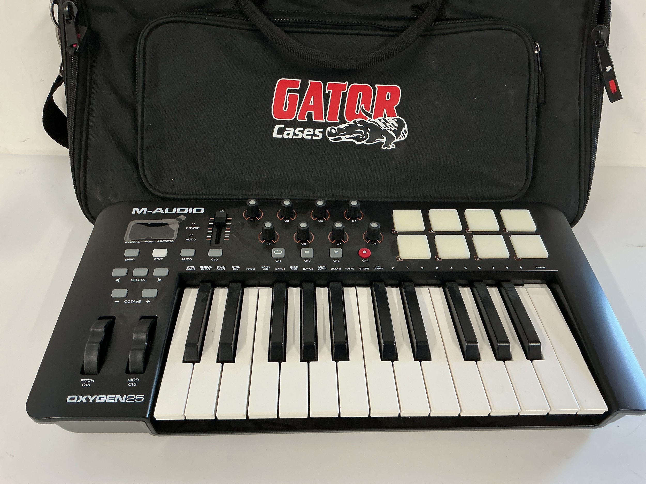 An M-Audio 25 drum machine and a Gator carry case.