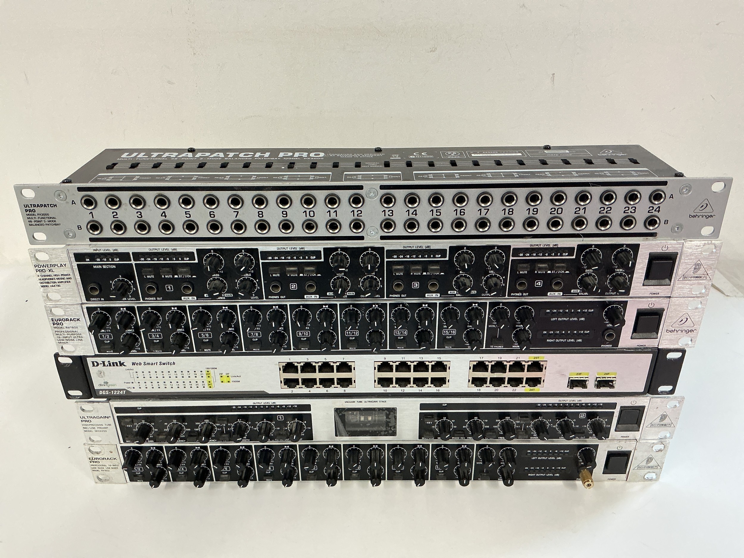 A collection of rack effects units comprising two Behringer line mixers, Ultragain Pro pre amp, Powerplay Pro X, Ultrapatch Pro patch bay and a D Link DGS 1224T.