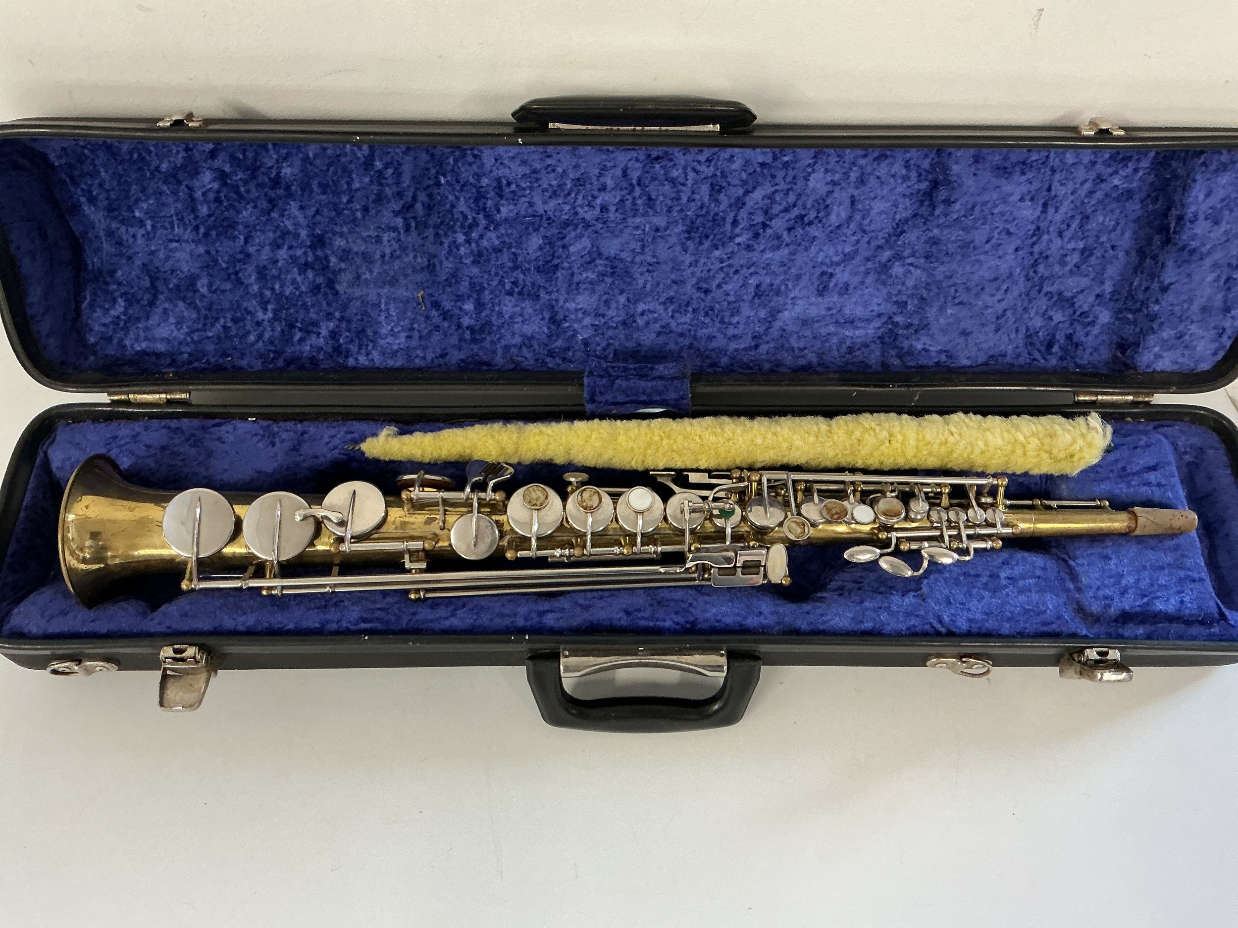 A cased soprano saxophone. In need of attention, pads missing.