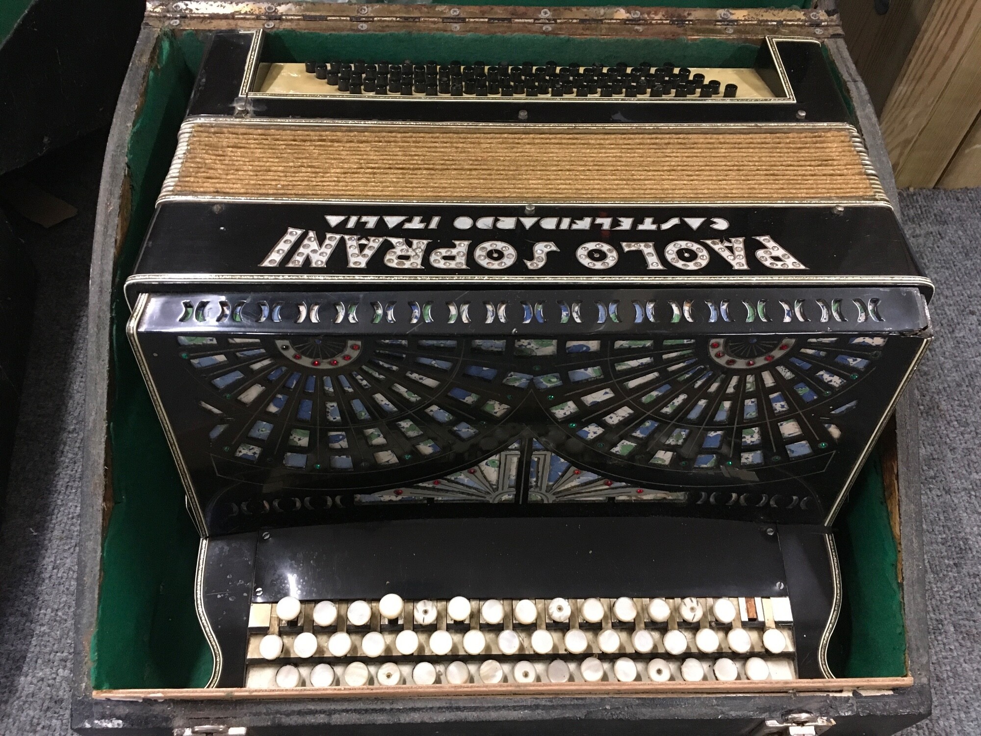 A Paolo Soprani button accordion in a fitted carry case.