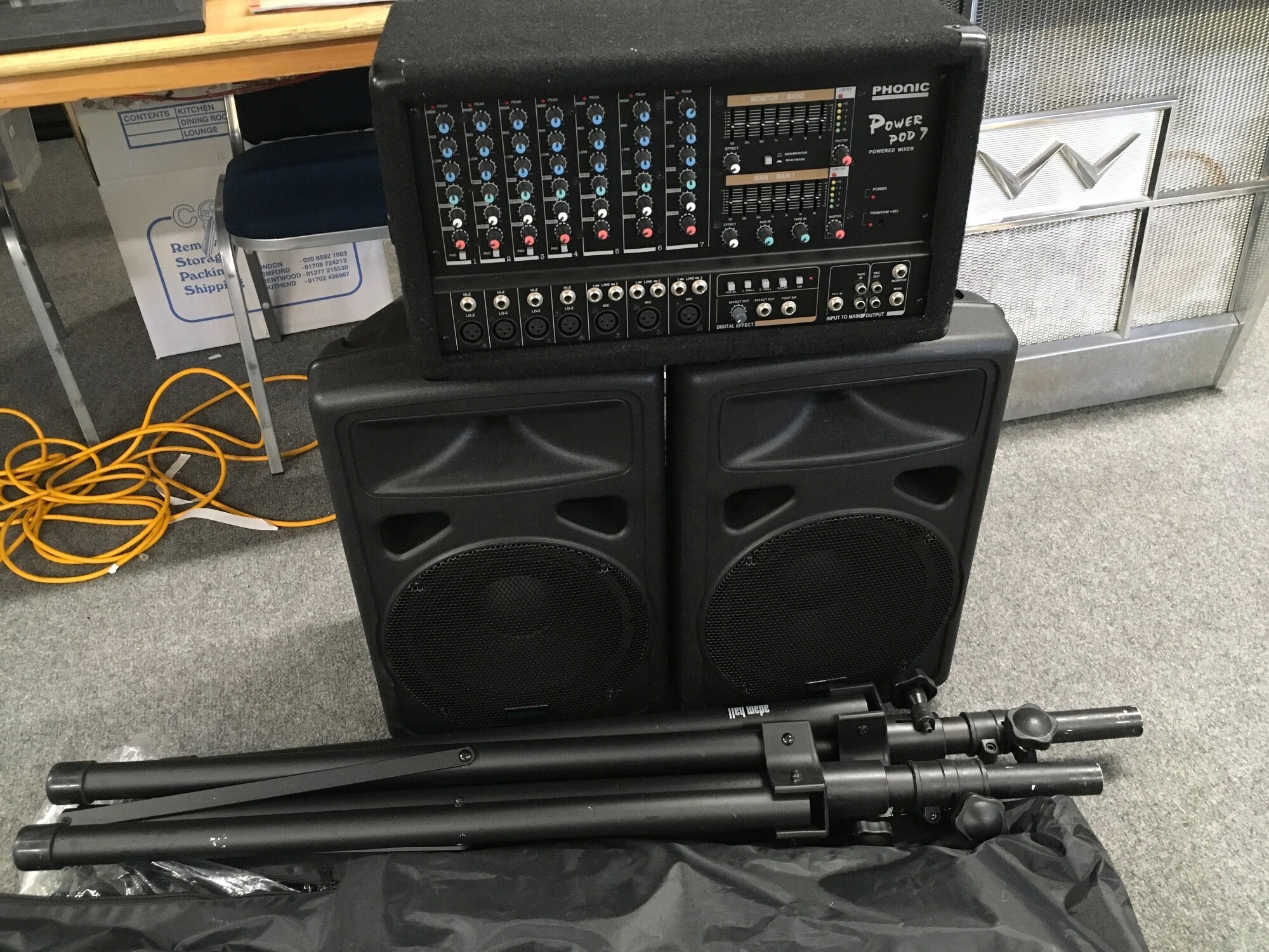 A Phonic Powerpod powered mixer, two Professional Speaker System passive speakers and pole mounts. Cables and manuals included.