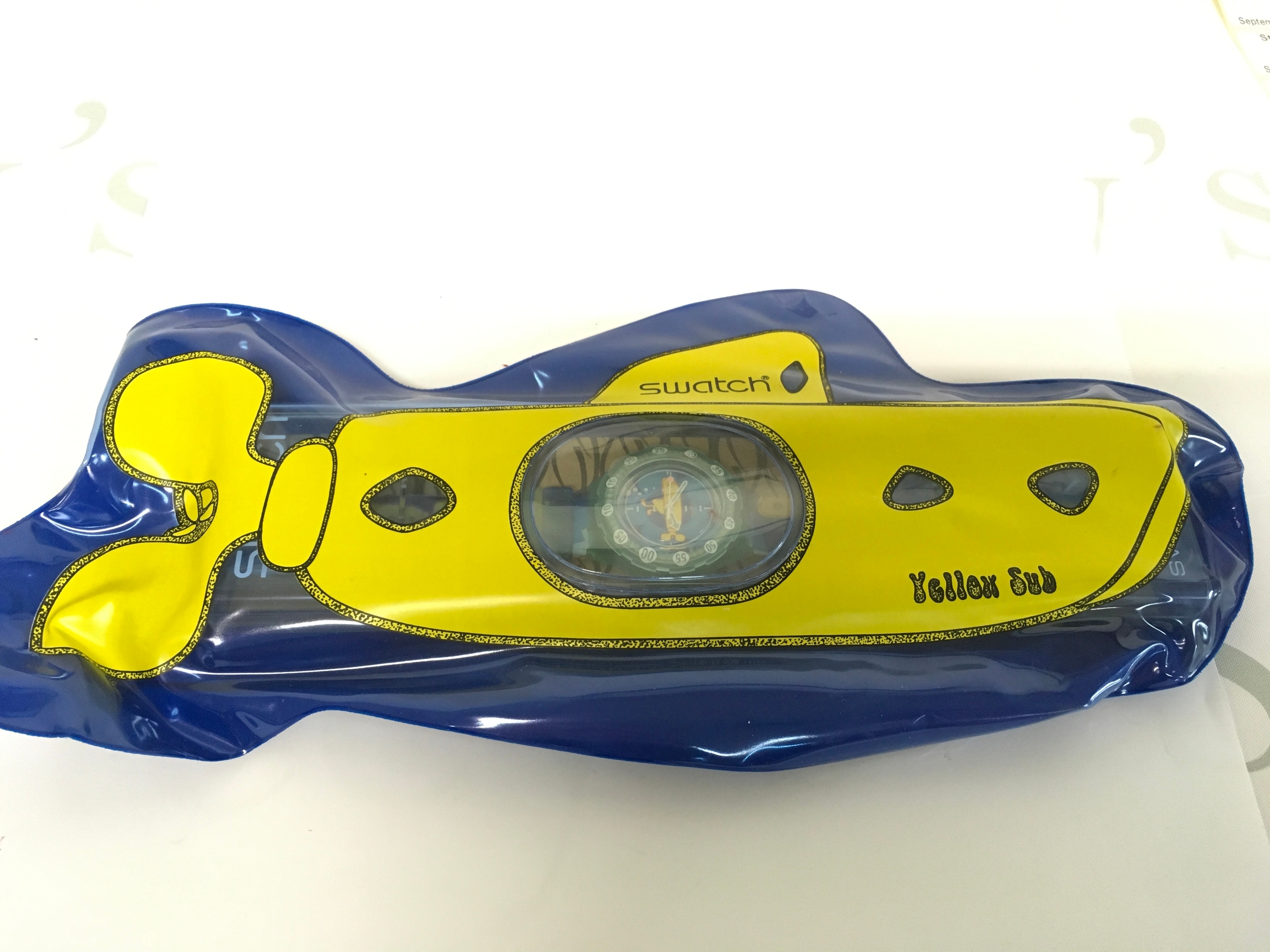 rare 1998 Swatch "Yellow Sub" Scuba 200 watch, model SDL101, inspired by The Beatles. It was part of a limited release that was quickly recalled due to legal issues, making original packaging highly sought after. The unique packaging includes a large inflatable yellow submarine that houses the watch case.