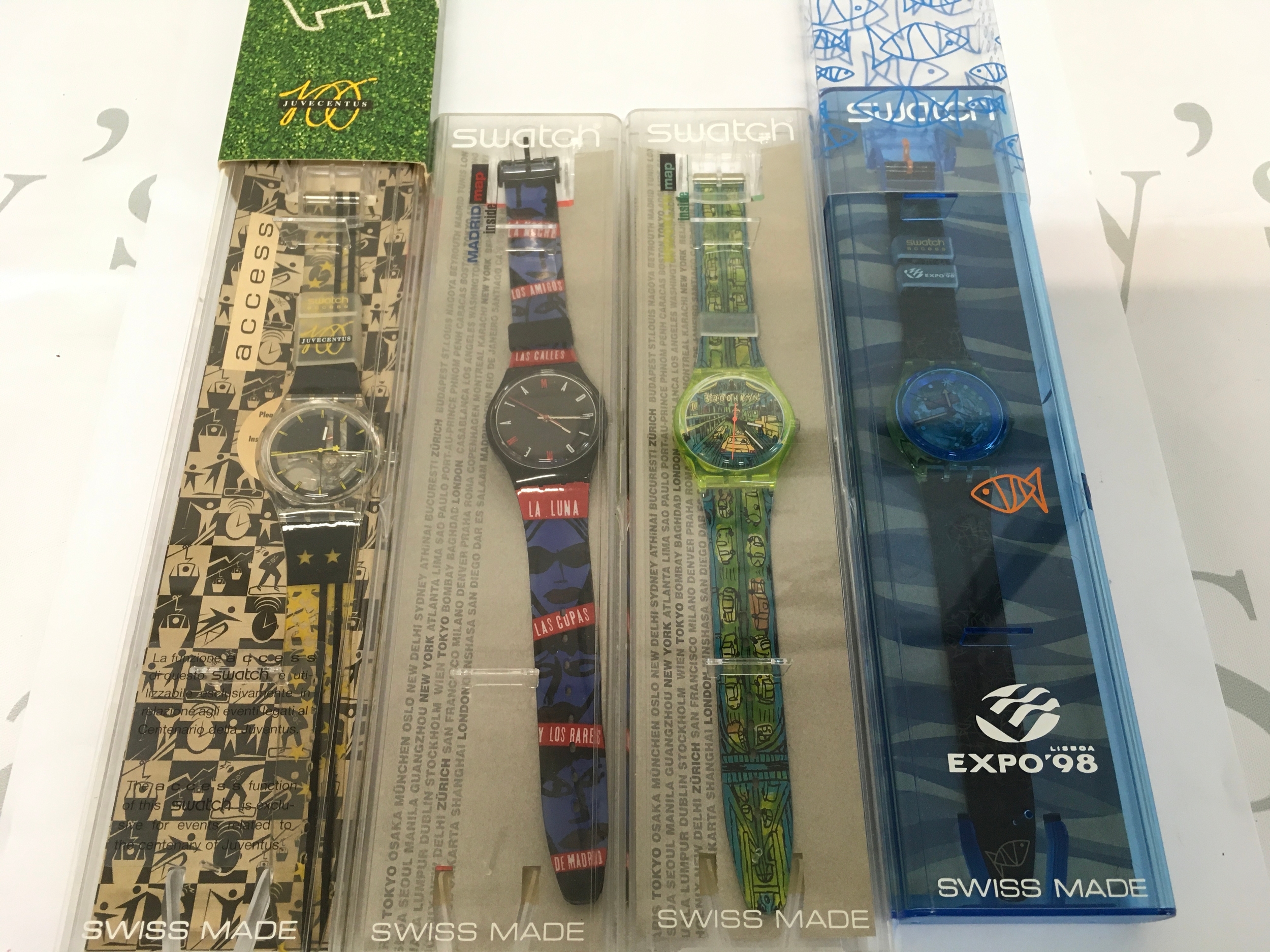 A collection of four vintage Swatch watch is the "Sueno Madrileno" model GB181, designed by Oscar Marine And a 1998 expo