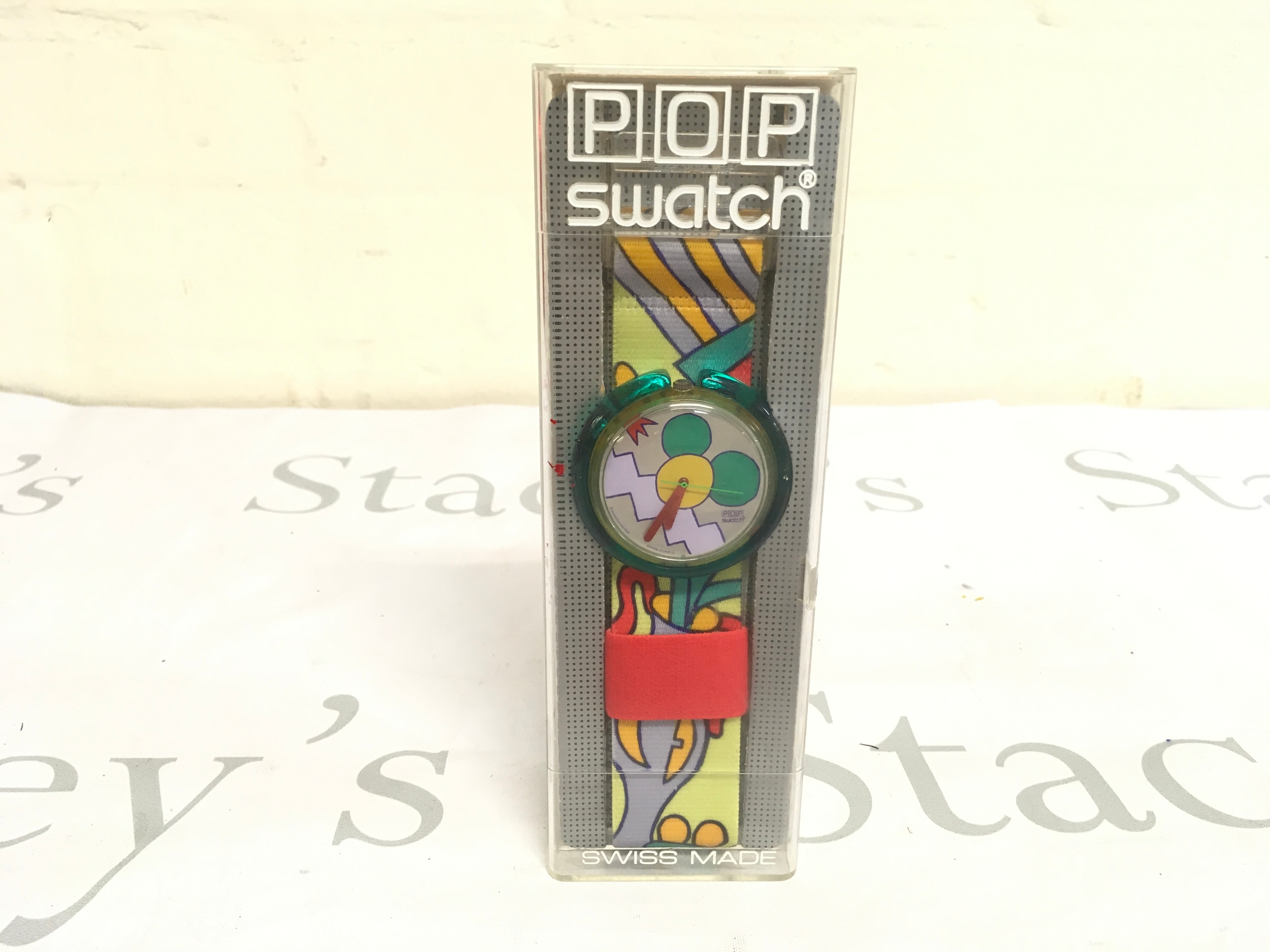 vintage Swatch Pop Milano (PWK151) watch from 1991 features a colorful, comic-style textile strap and a distinctive green plastic case.