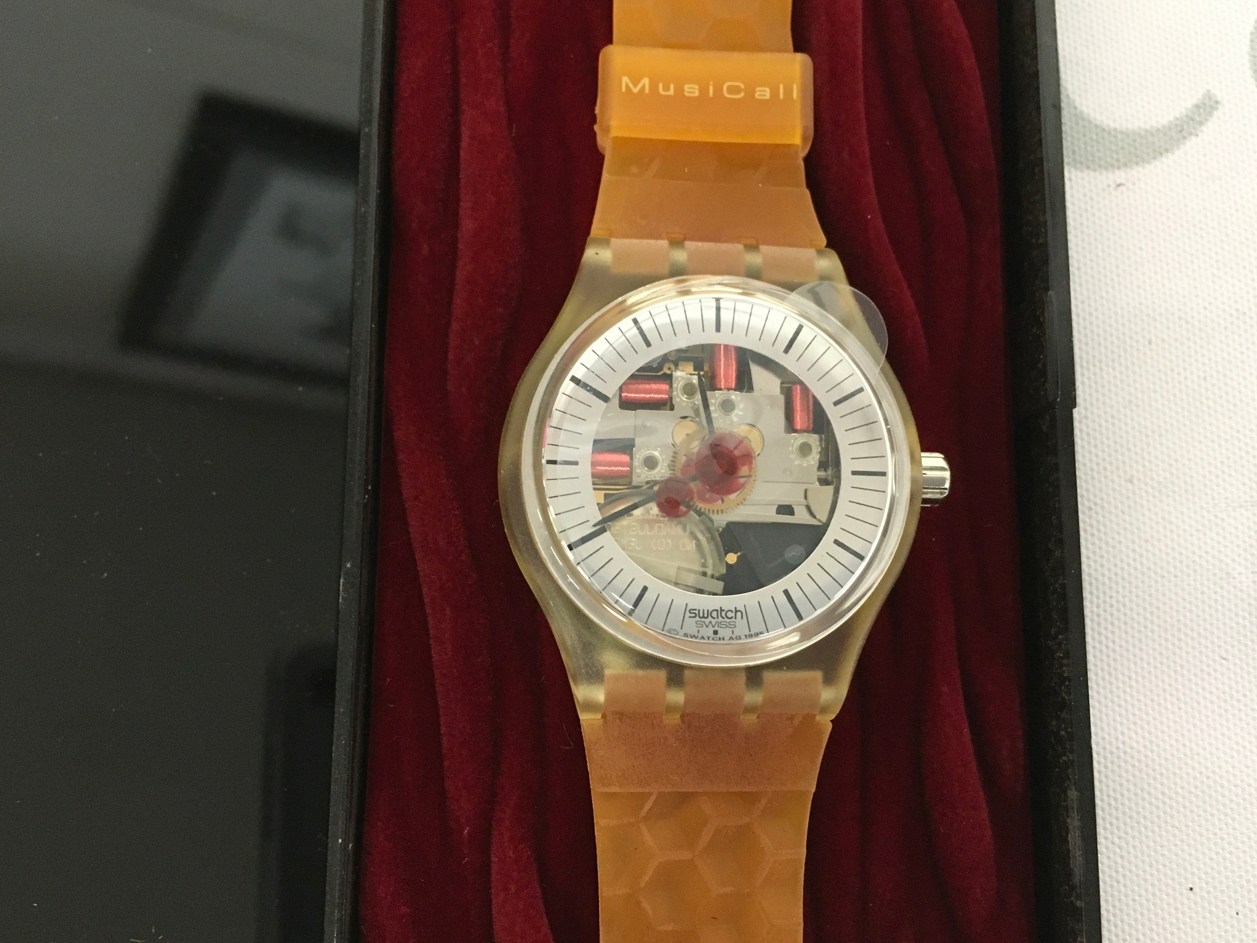 Swatch MusiCall "ADAM" (SLZ106) watch from 1995 featuring a melody composed by Peter Gabriel. It features a distinctive yellow plastic strap with a honeycomb pattern and a transparent watch case.