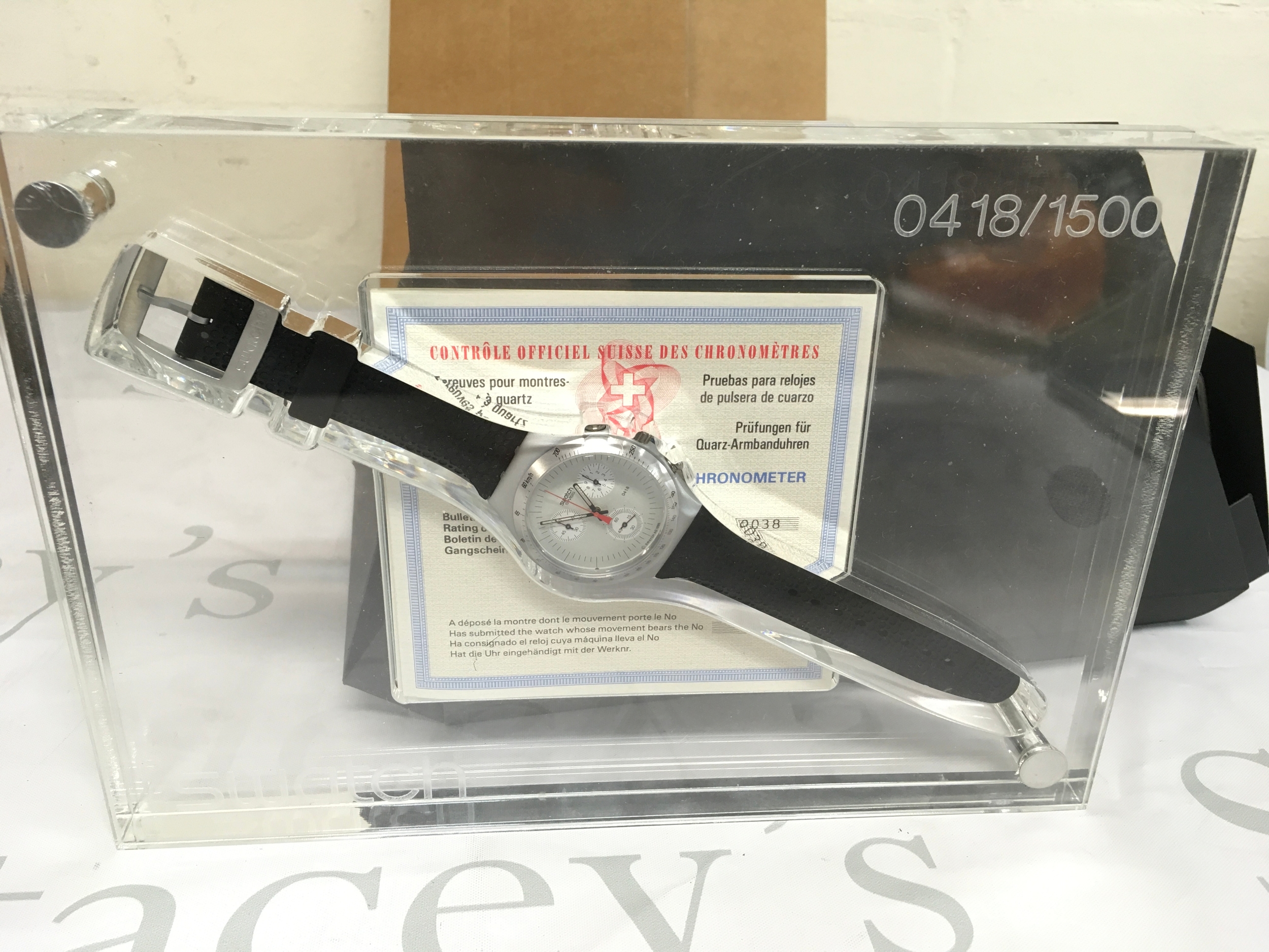 Swatch Irony Chrono "Time Cut" watch. This limited edition timepiece was released in 1995 with only 1,500 units produced worldwide. The watch features a metal case, a quartz movement, and is presented in a unique clear plastic display case. The set includes original paperwork, specifically a chronometer rating certificate