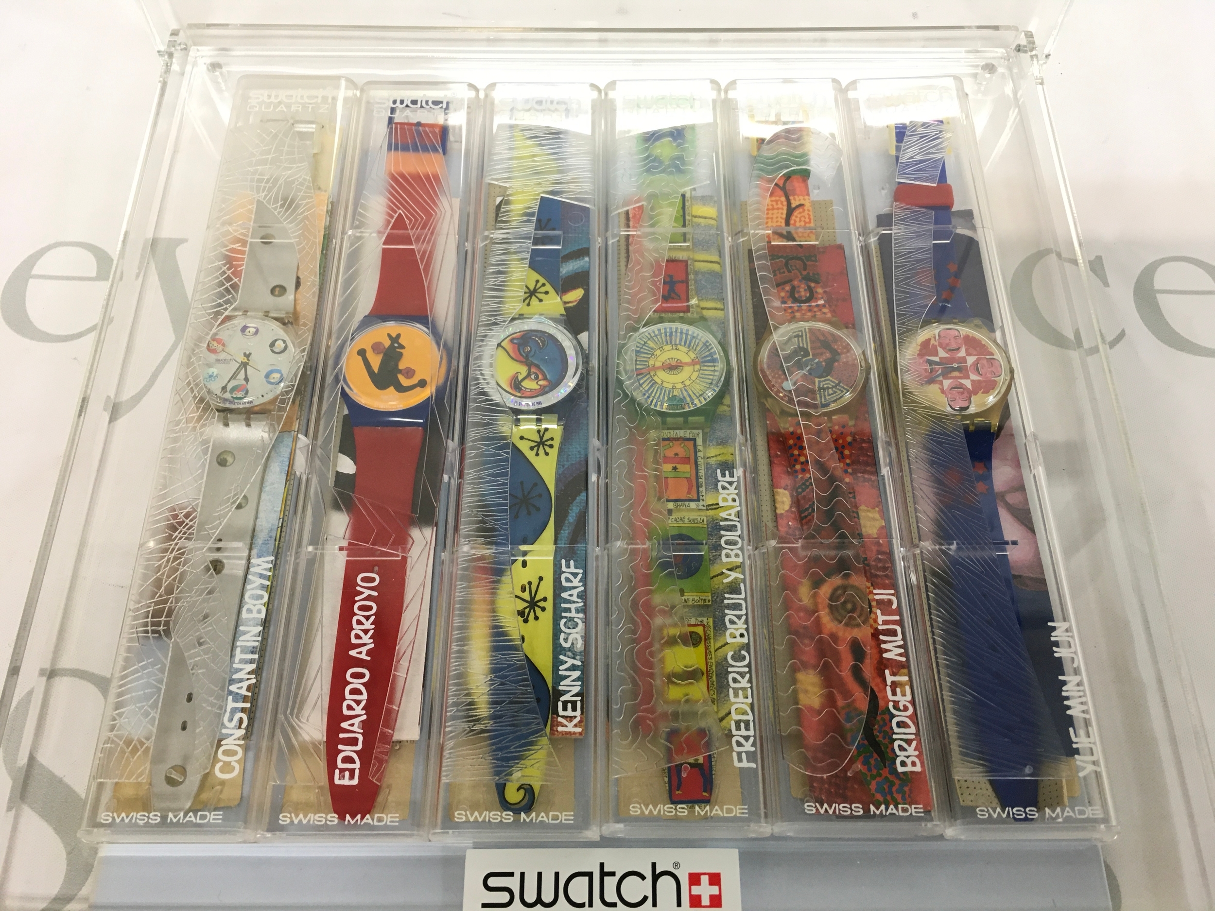 complete six-piece Swatch Artist Collection set housed in its original clear plastic special packaging. The collection features watches designed by Constantin Boym, Eduardo Arroyo, Kenny Scharf, Frederic Bruly Bouabre, Bridget Mutji, and Yue Min Jun.