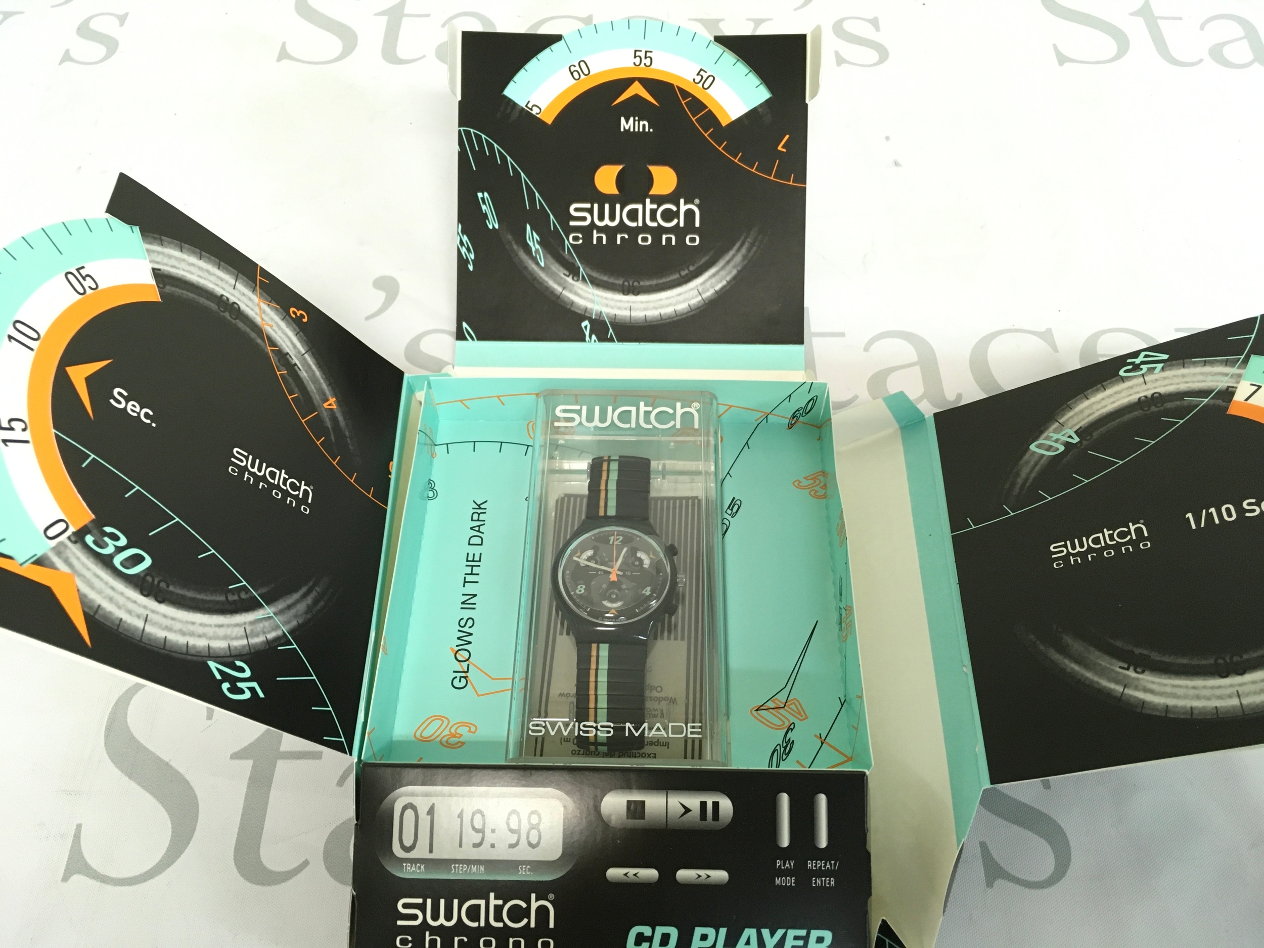 Swatch Chrono "CD Player" watch, specifically model SCB120from 1997-1998, featuring a glow-in-the-dark face and a specialised themed packaging.