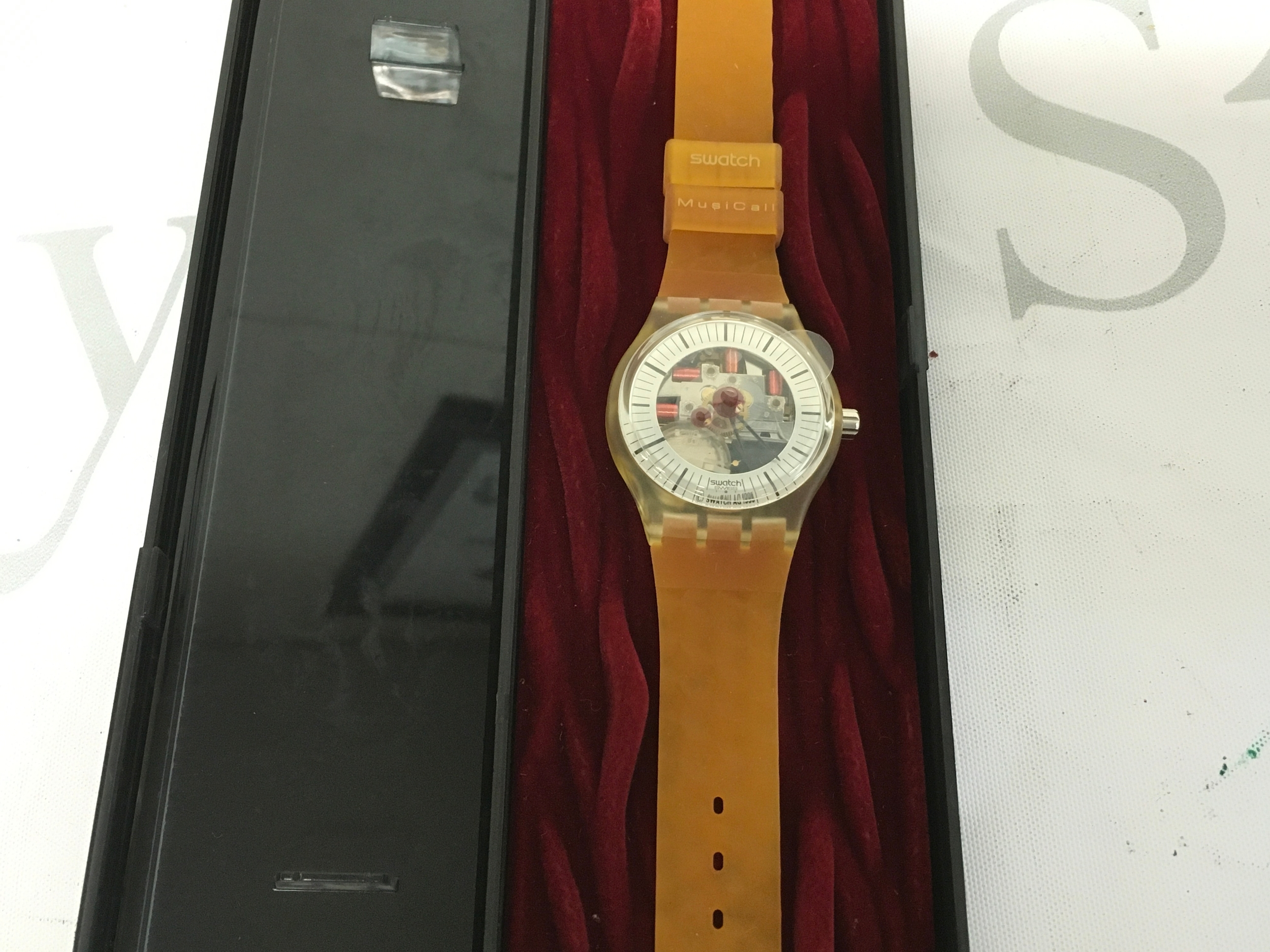 vintage 1995 Swatch MusiCall watch, model "Adam" SLZ106, designed in collaboration with Peter Gabriel. It features a transparent dial that reveals the internal quartz movement components, including the alarm mechanism.