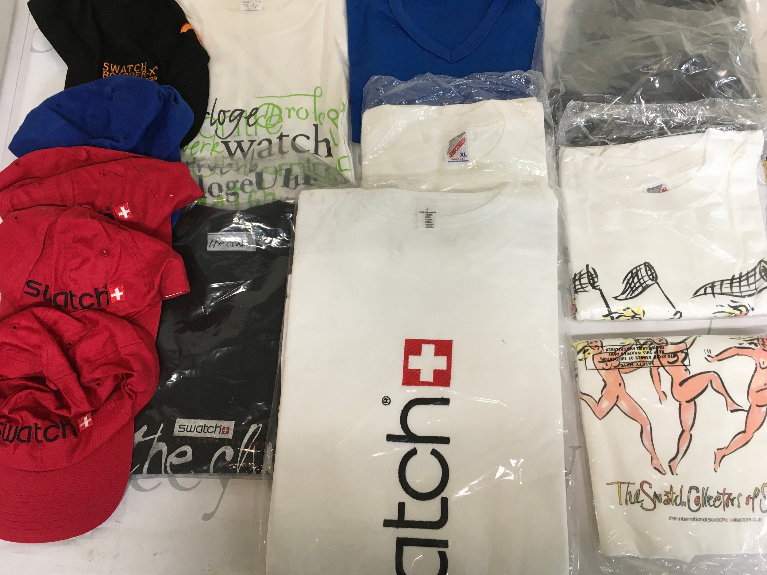 A collection of assorted swatch T-shirts and caps