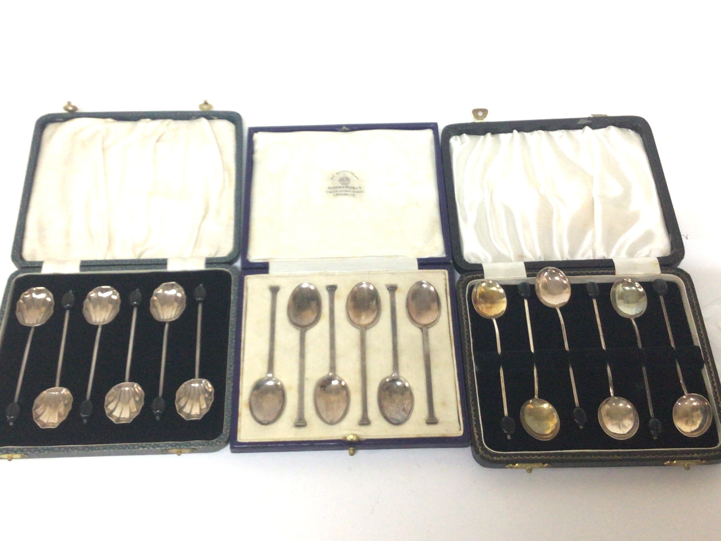 Three cased sets of silver coffee spoons including a set by Mappin & Webb.