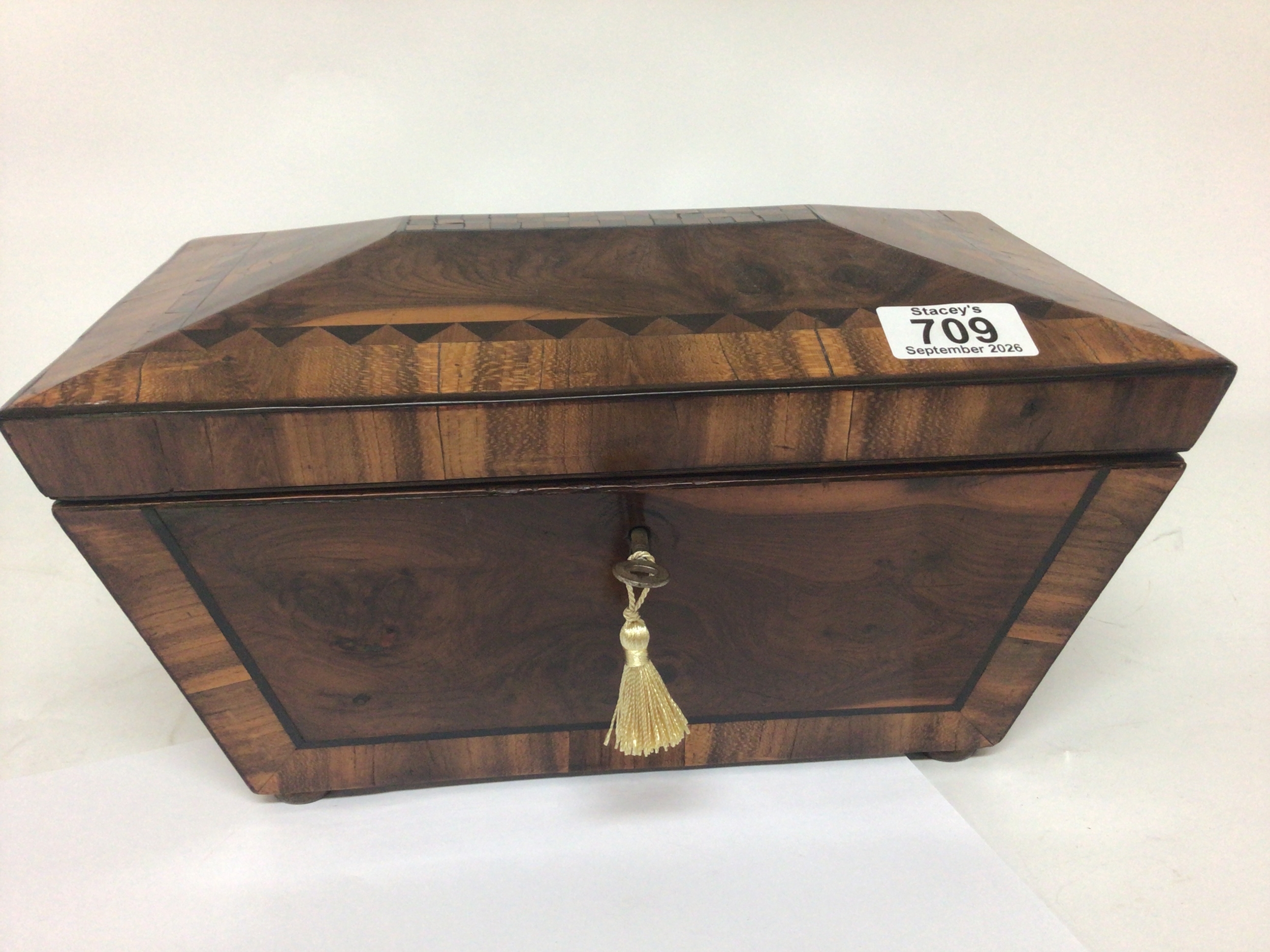 A quality early 19th century tea caddy with veneered specimen woods in a geometric design no interior. With key. 