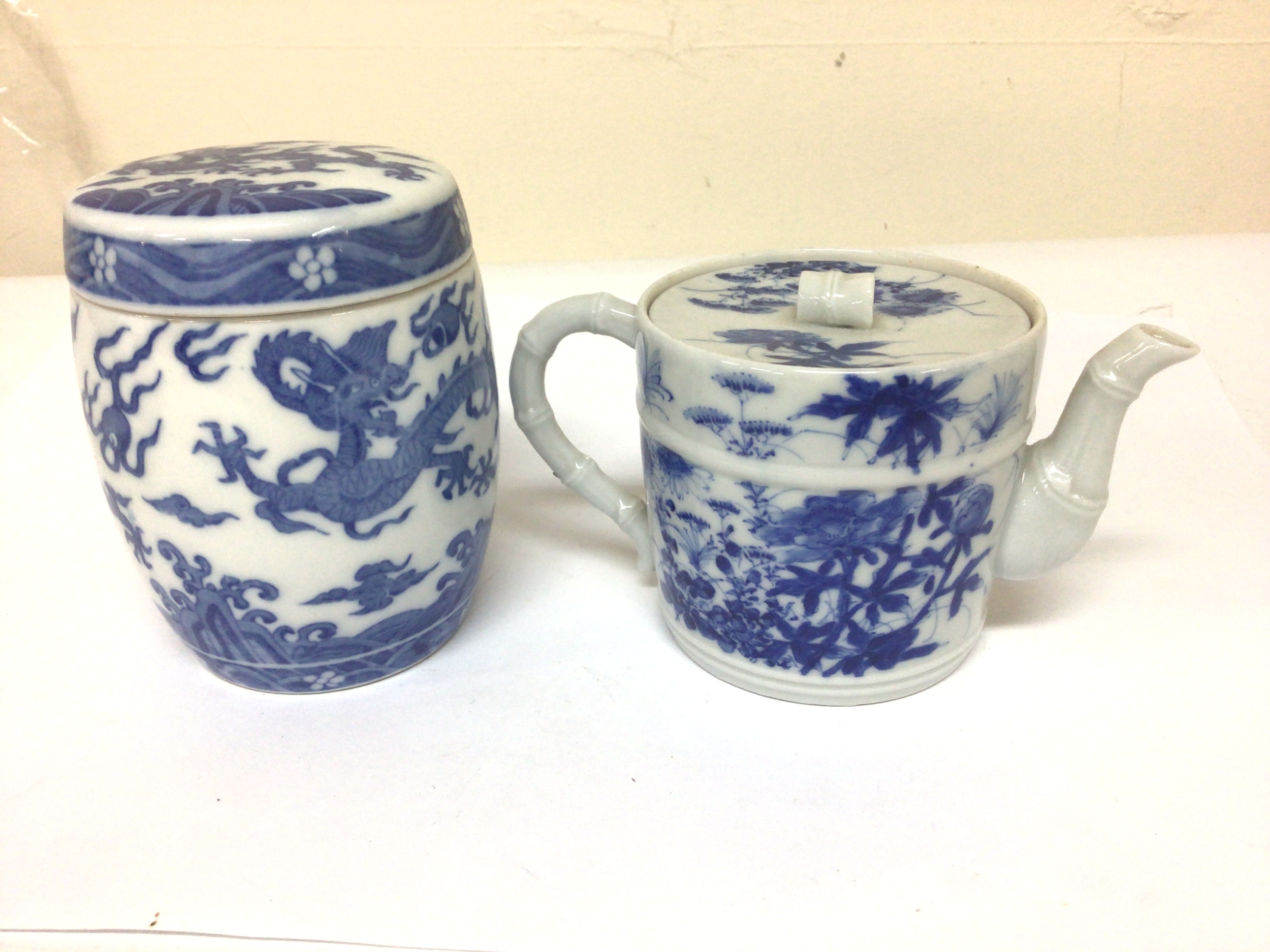  A Japanese blue and white porcelain tea pot simulated bamboo moulding with caricature marks to the base no obvious damage height 9cm and a Chinese export porcelain blue and white jar and cover with retrospective Ming Dynasty six caricature marks 20th century no obvious damage. Hight 11.5cm (2) 