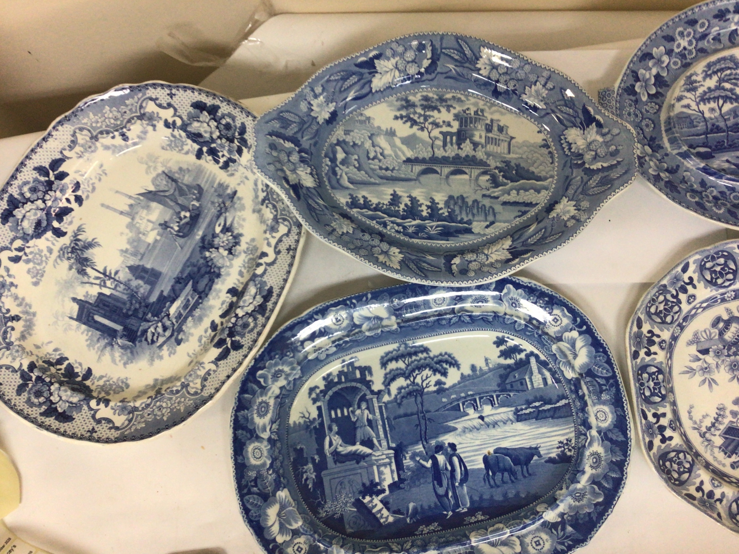 A collection of Victorian blue and white meat plates decorated with pseudoclassical views and landscapes with buildings one with a chipped edge one with cracks otherwise good condition in keeping with age. 