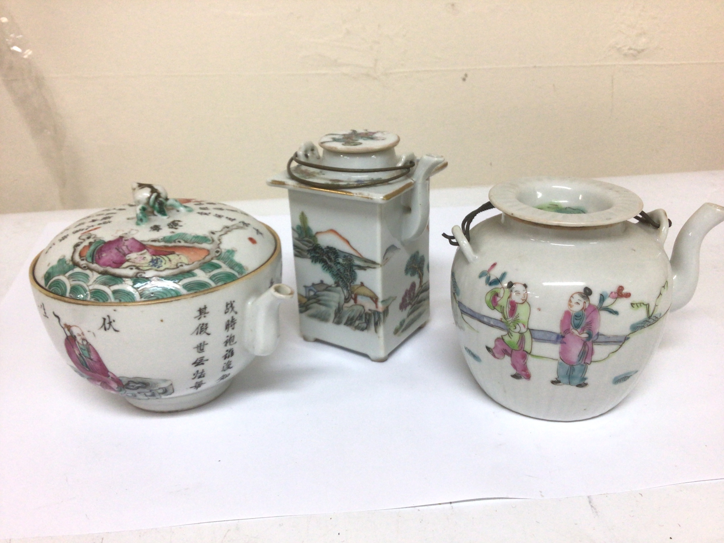  A 19th century Chinese export porcelain famile rose tea pot decorated with script and two other Chinese tea pots early Republic. No obvious damage condition in keeping with age maximum height 12cm. 