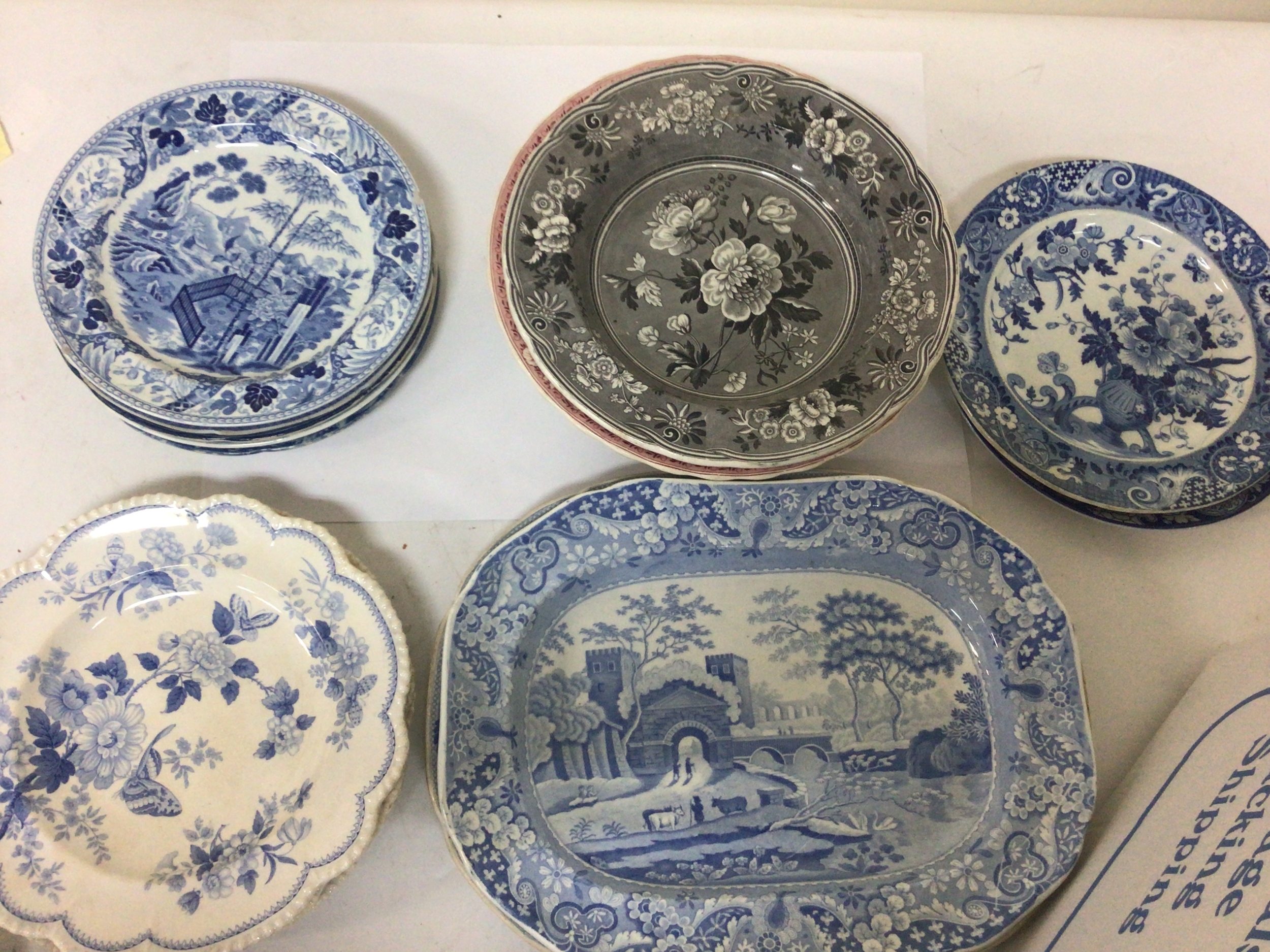 A box containing Victorian and other decorative blue and white plates. Including Spode.