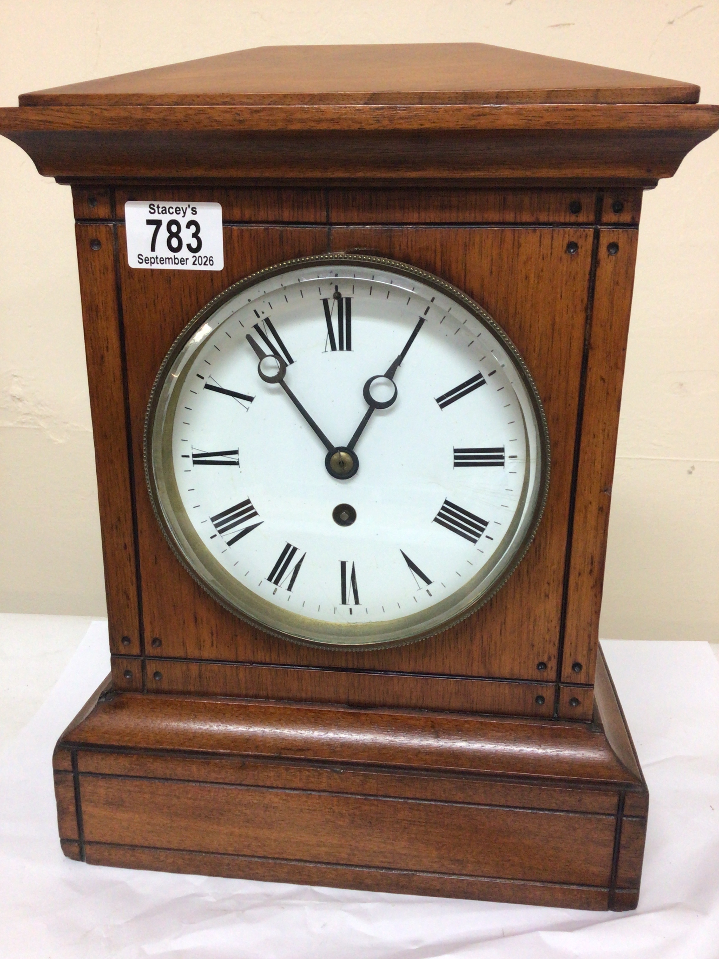 A Victorian mantel clock with a walnut case and enamel dial and French brass movement with a pendulum. Hight 37cm
