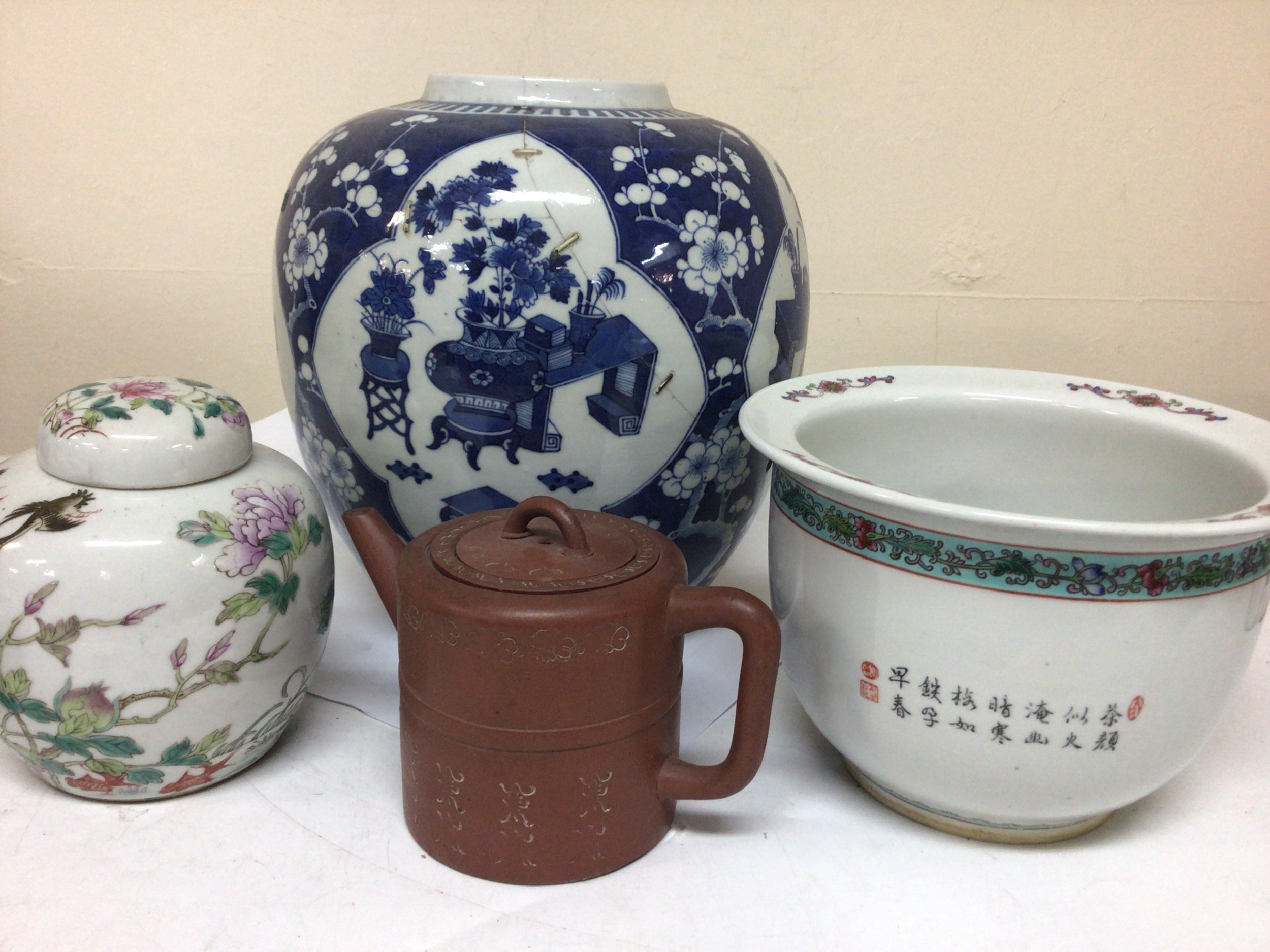  A Chinese Export porcelain blue and white jar (damaged) an Earthenware Chinese tea pots caricature marks to the base a polychrome Chinese 19th century ginger jar and cover and Republic jardiniere (4) maximum height 26cm 