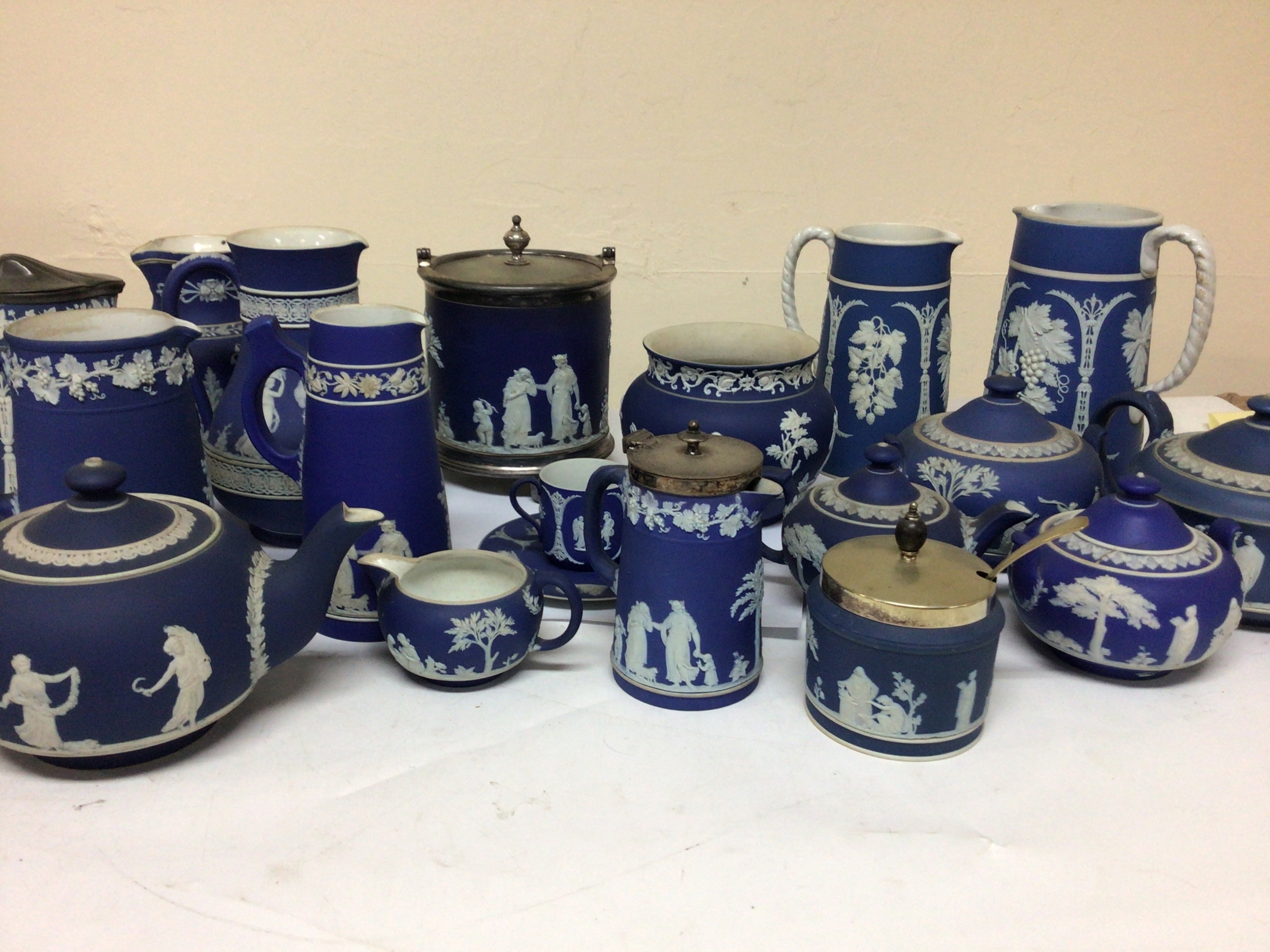  A good collection of Victorian and later Wedgwood jasper ware decorated with Neo-classical figures jugs tea pots biscuit barrel small jardiniere etc. most items without damage cracked sugar bowl chip to jug rims otherwise no obvious damage. 