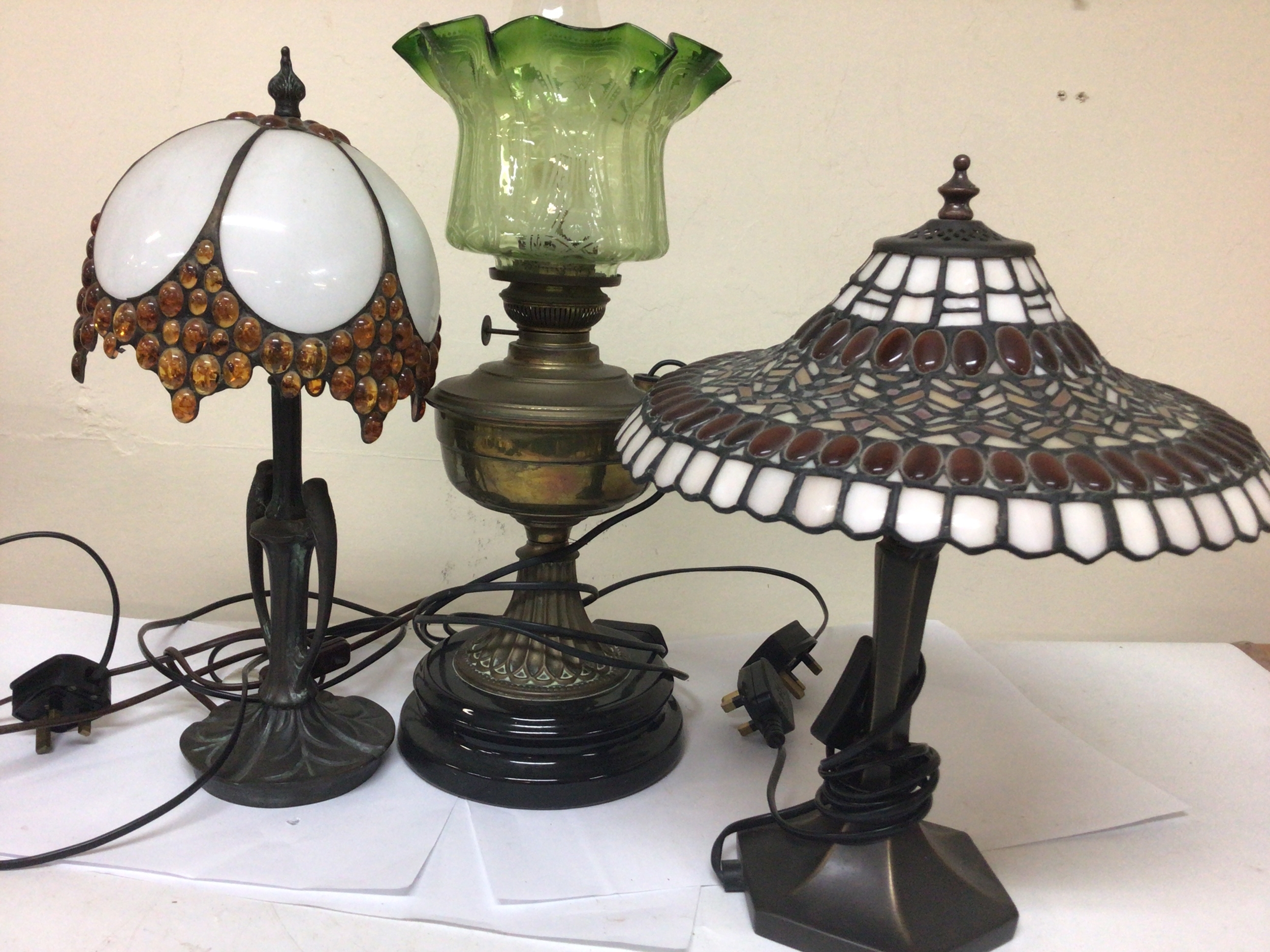  Two Tiffany style table lamps and a Converted Victorian oil lamp with a green glass shade. (3) 