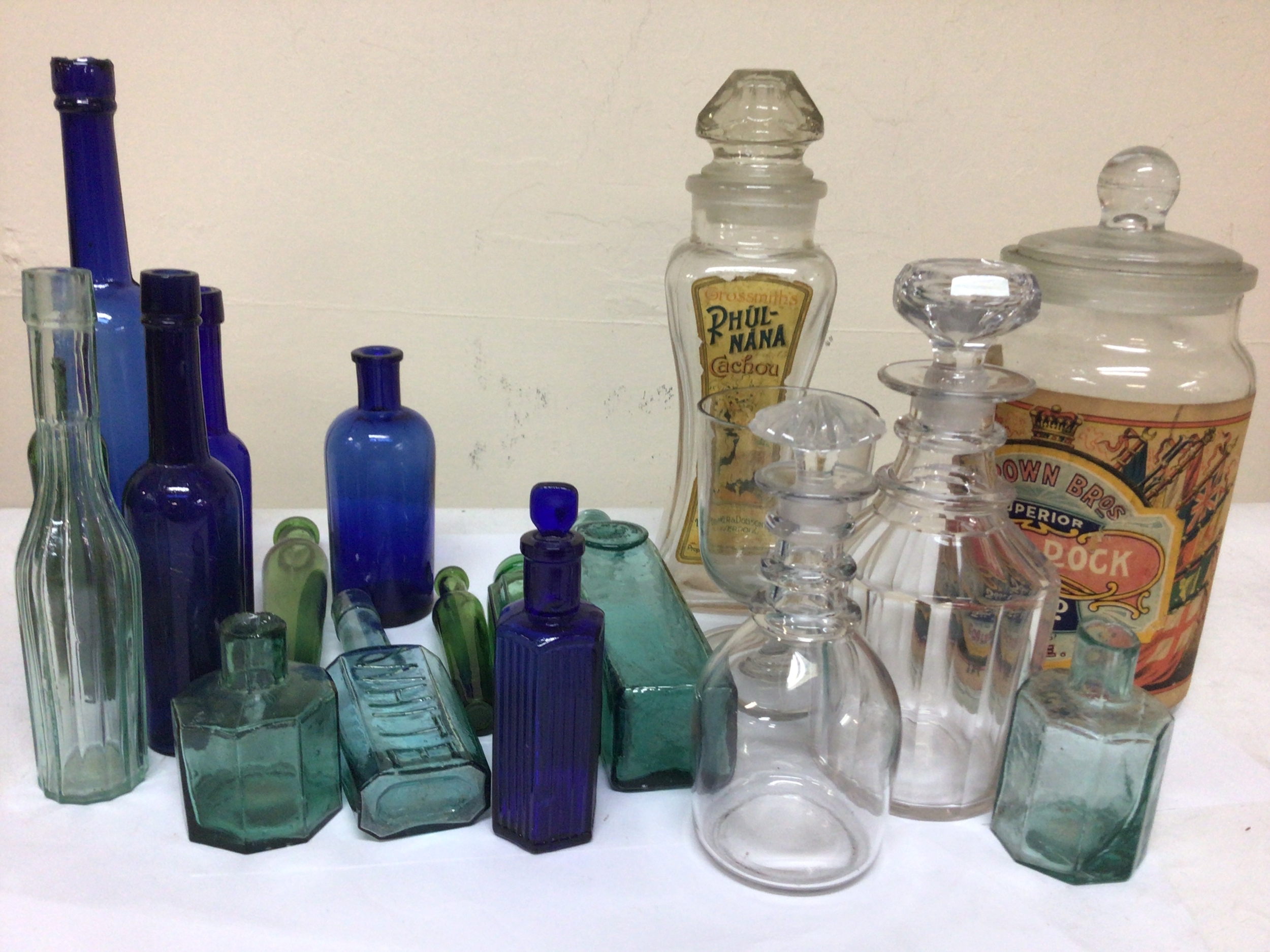  A collection of Victorian and later glass bottles including blue Poison bottles small decanters and other glass. 