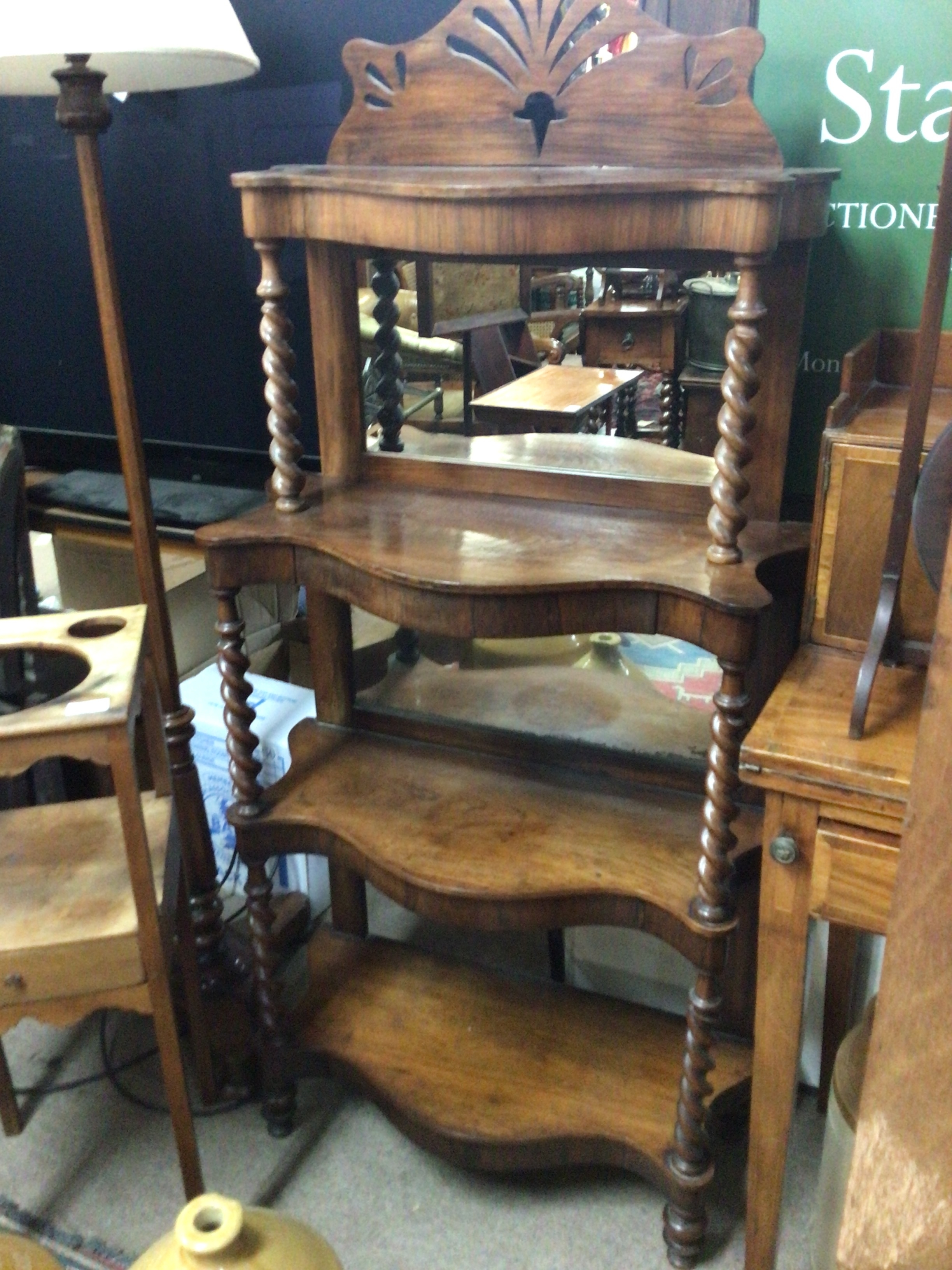 A Victorian Rosewood stand with open shelf's on barley twist supports with a mirrored back four tier. Height 150cm 
