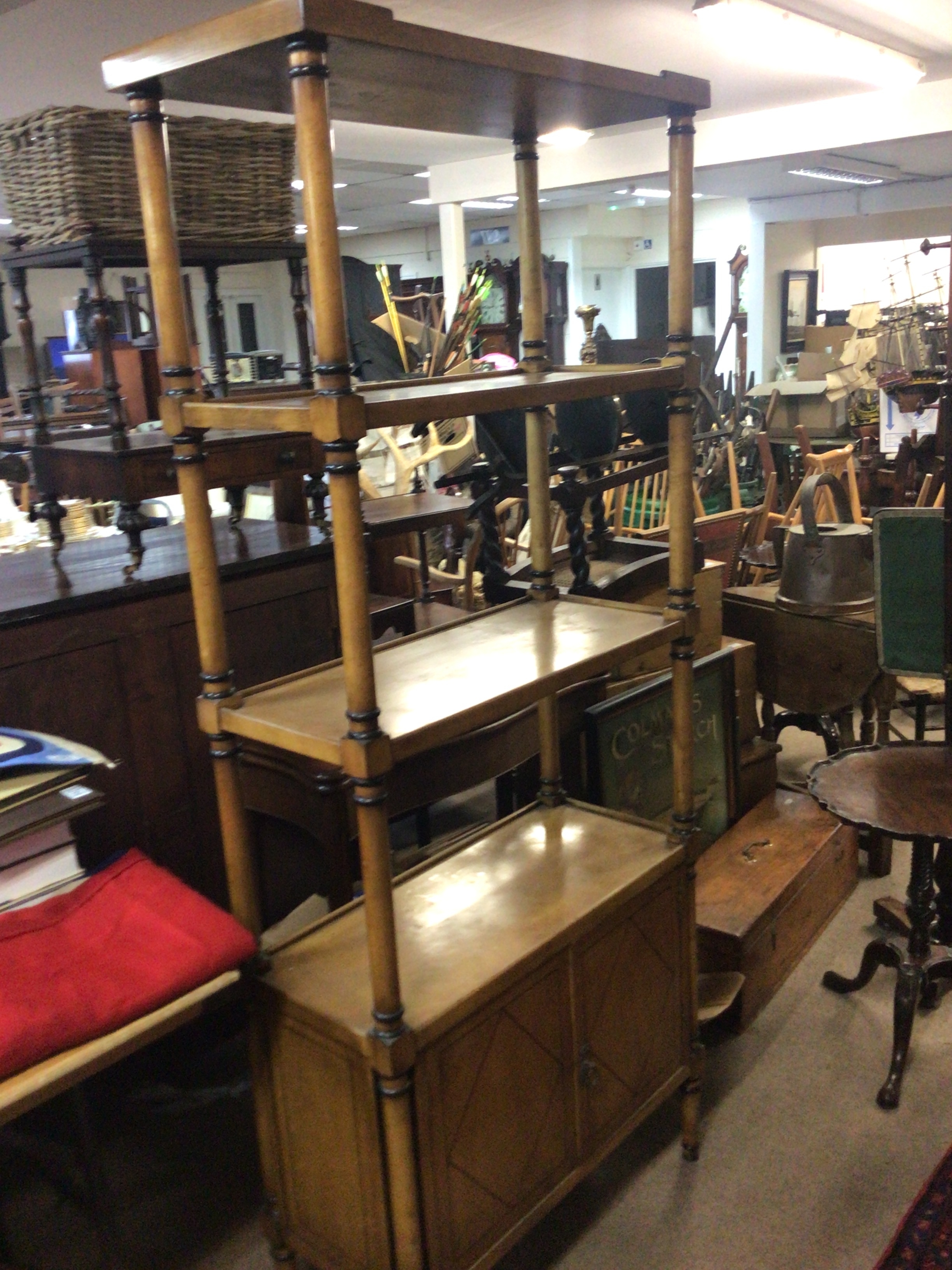 A Regency Style  burr maple and beechwood open display stand with three rectangular shelves above two doors with ebony banding.