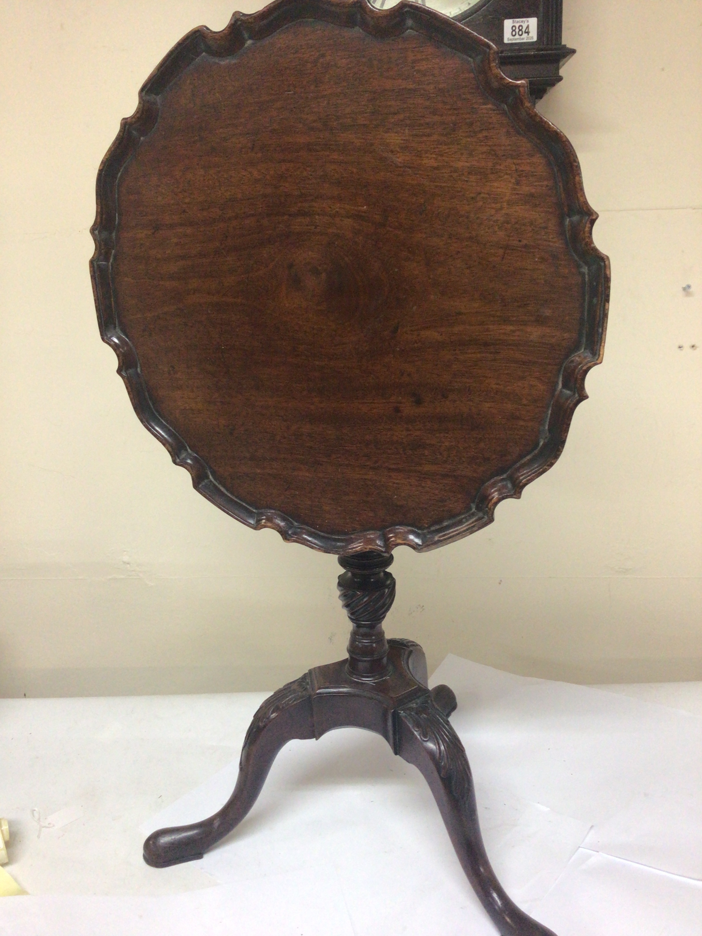  A George III mahogany occasional table with a hinged top and spiral fluted column on cabriole legs pad feet. 