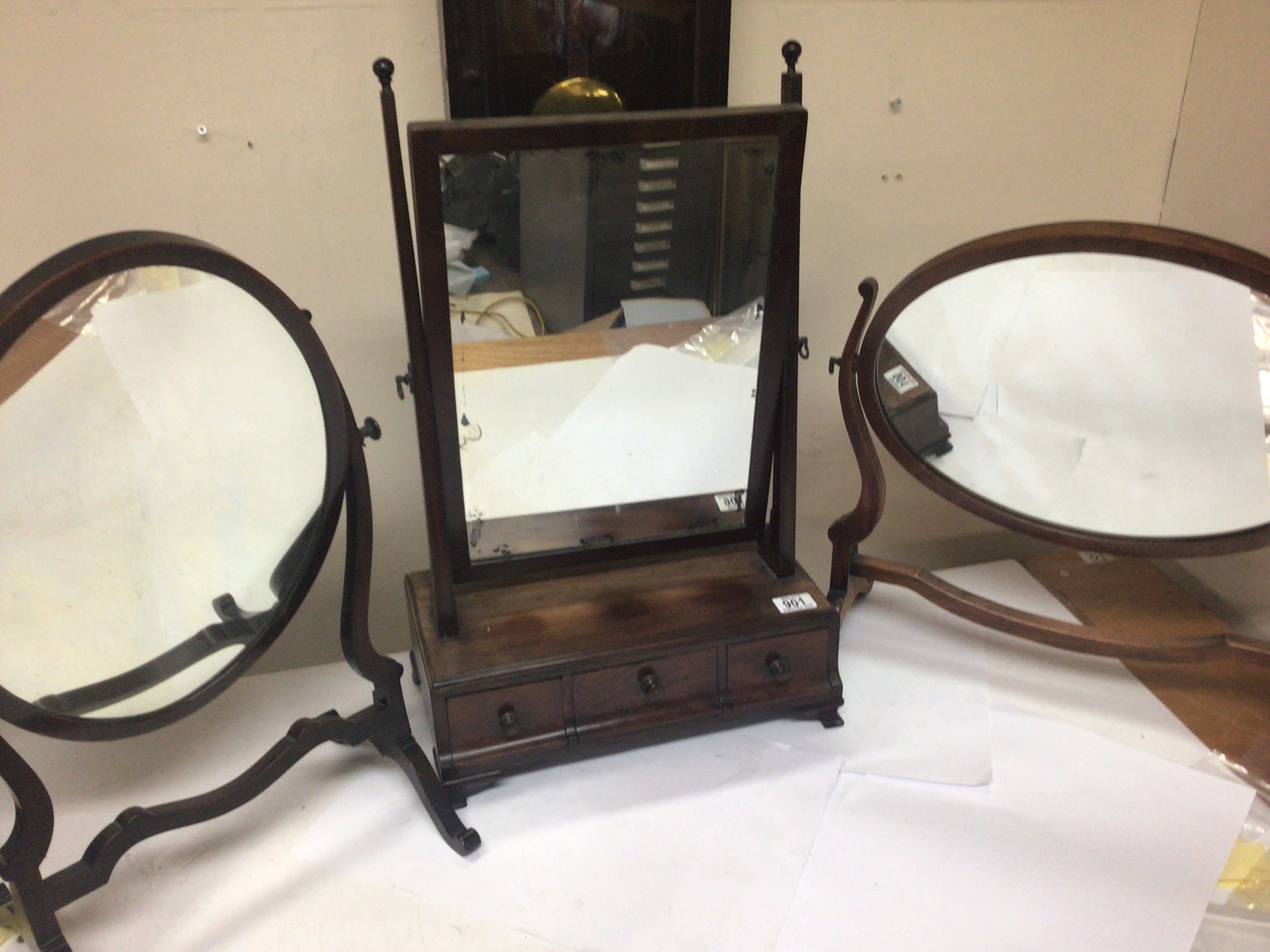  A George III mahogany dressing mirror of rectangular shape above three drawers   and oval mirrors. 