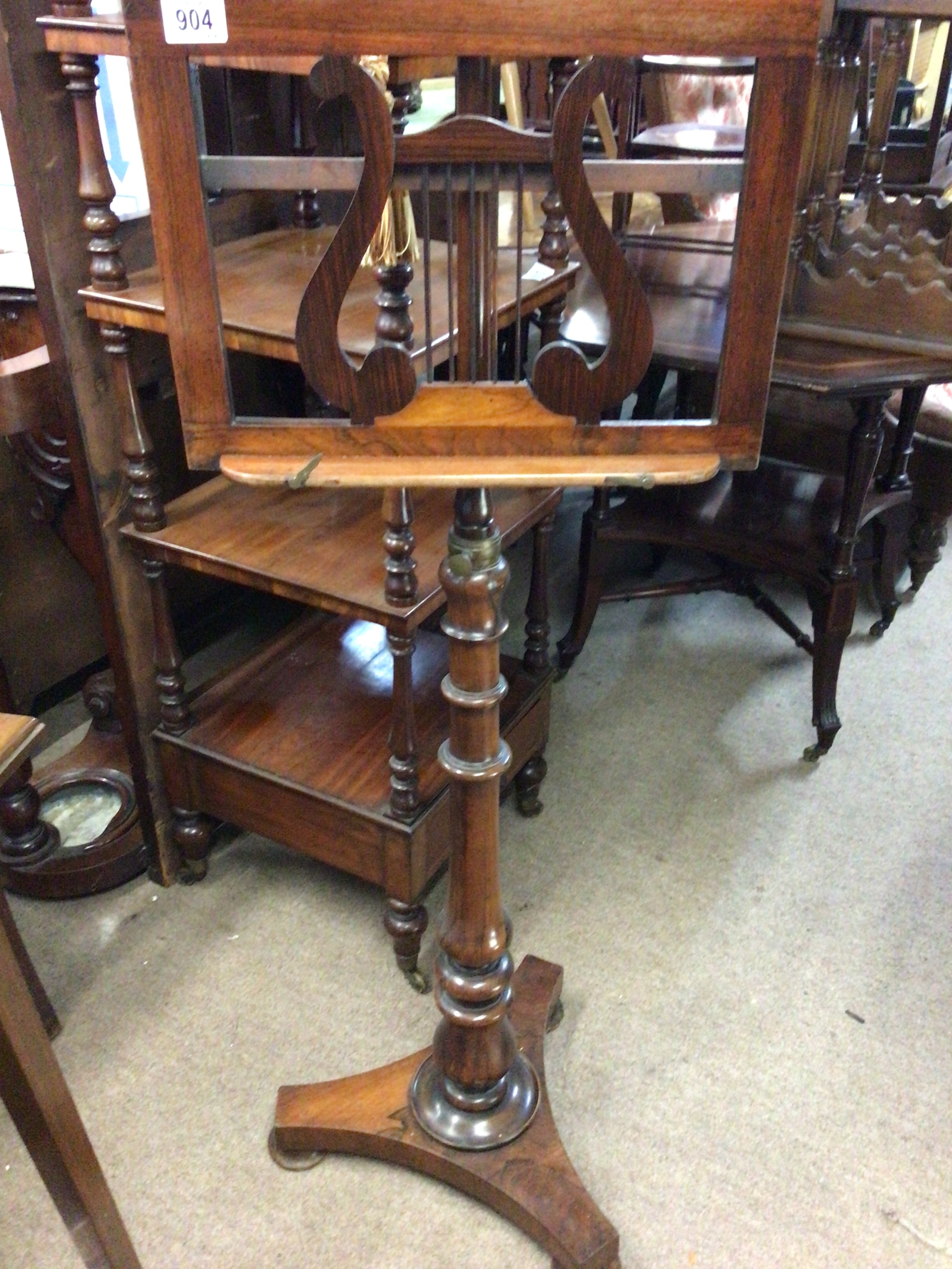  A quality Victorian Rosewood music stand with a harp scroll on an adjustable turned column.