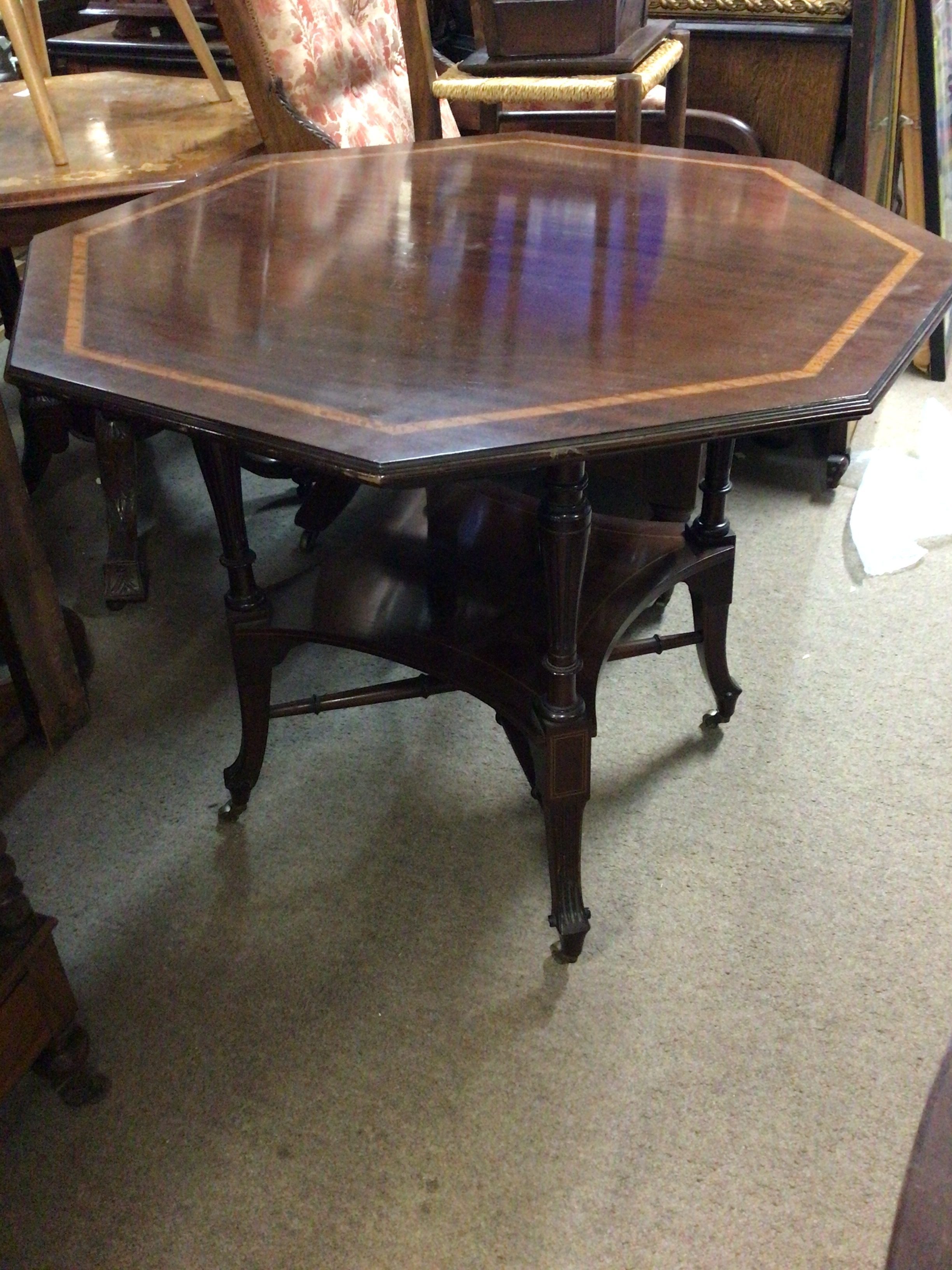   An Edwardian mahogany and satinwood banded octagonal top table on fluted legs untied by an under shelf. 88cm wide 