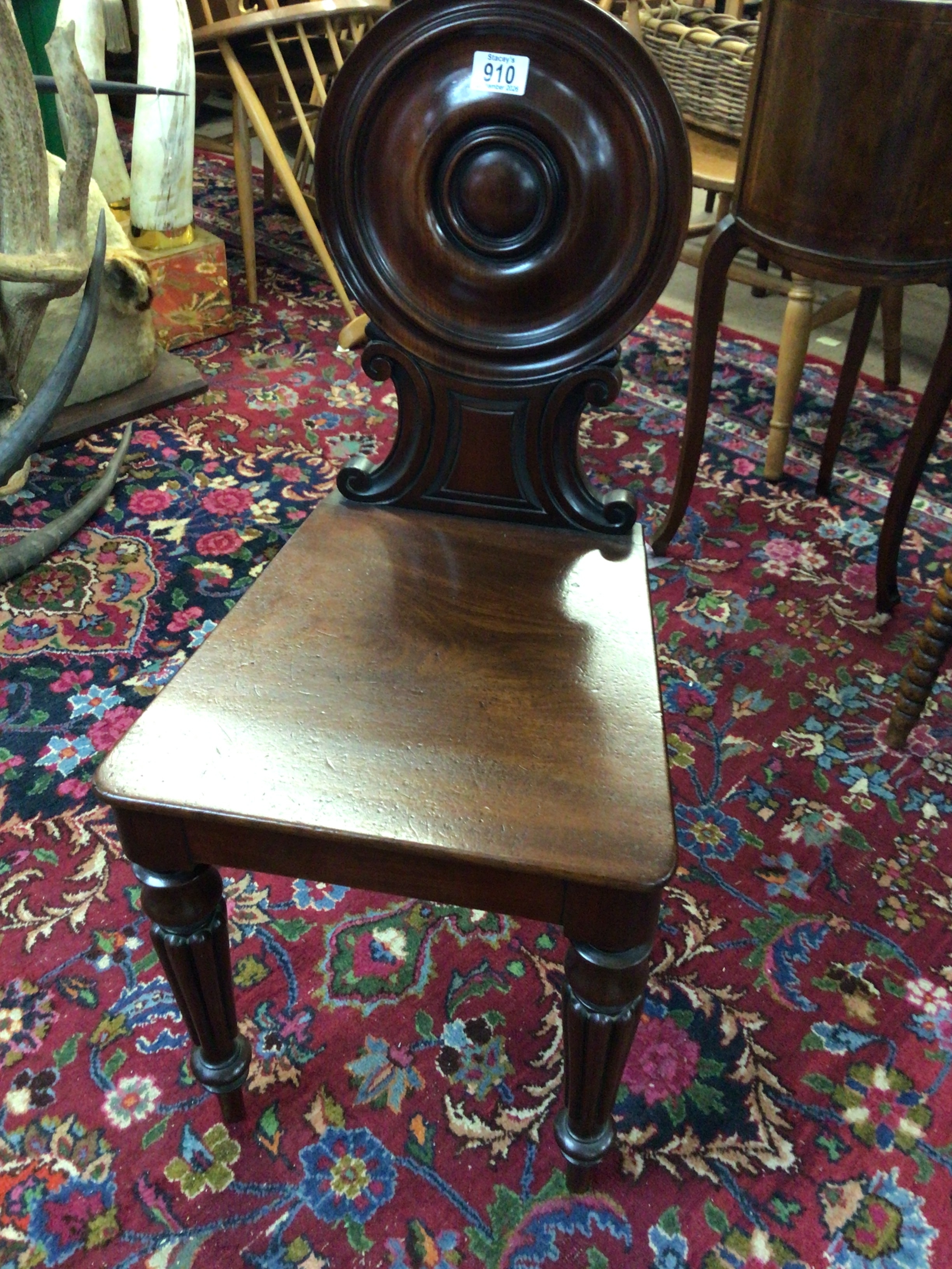 A Quality late Regency Mahogany hall chair with a shaped back and solid seat on fluted legs. 