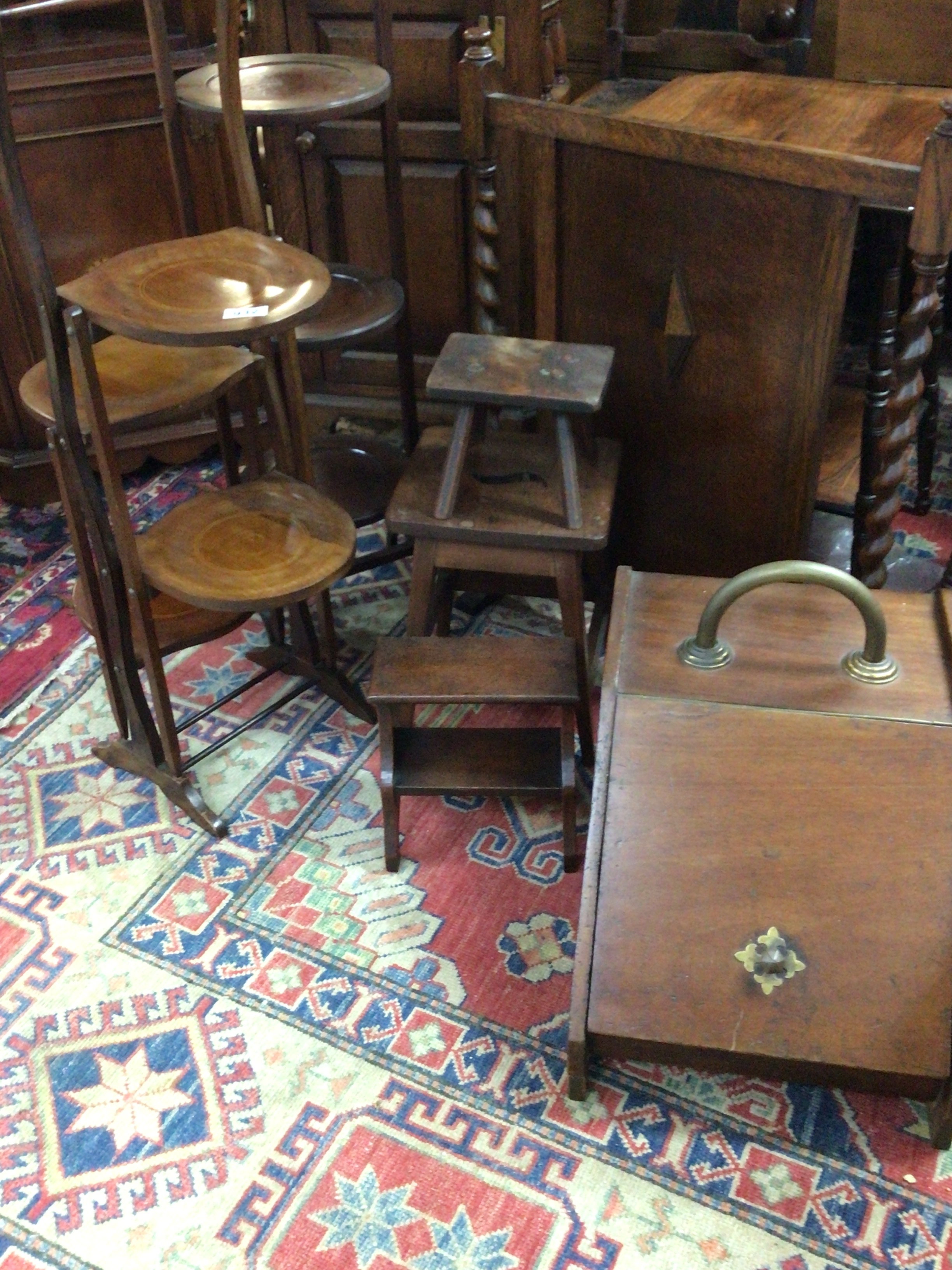  A collection of Edwardian and Victorian furniture comprising Venacular stools mahogany cake stands an oak fire screen and a coal box. 