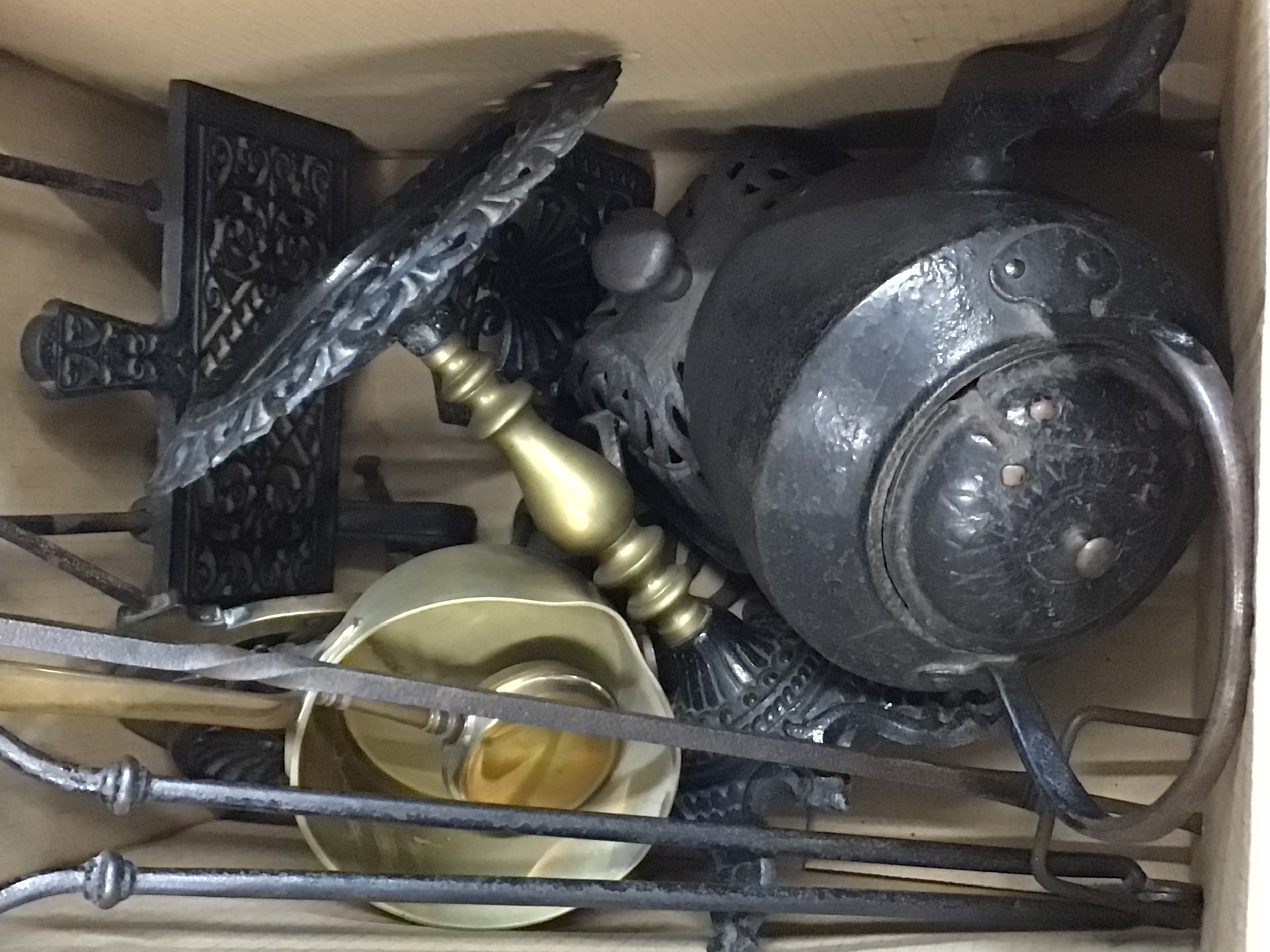 A box containing Victorian cast metal and brass fire companions trivets stands saucepans and other oddments 