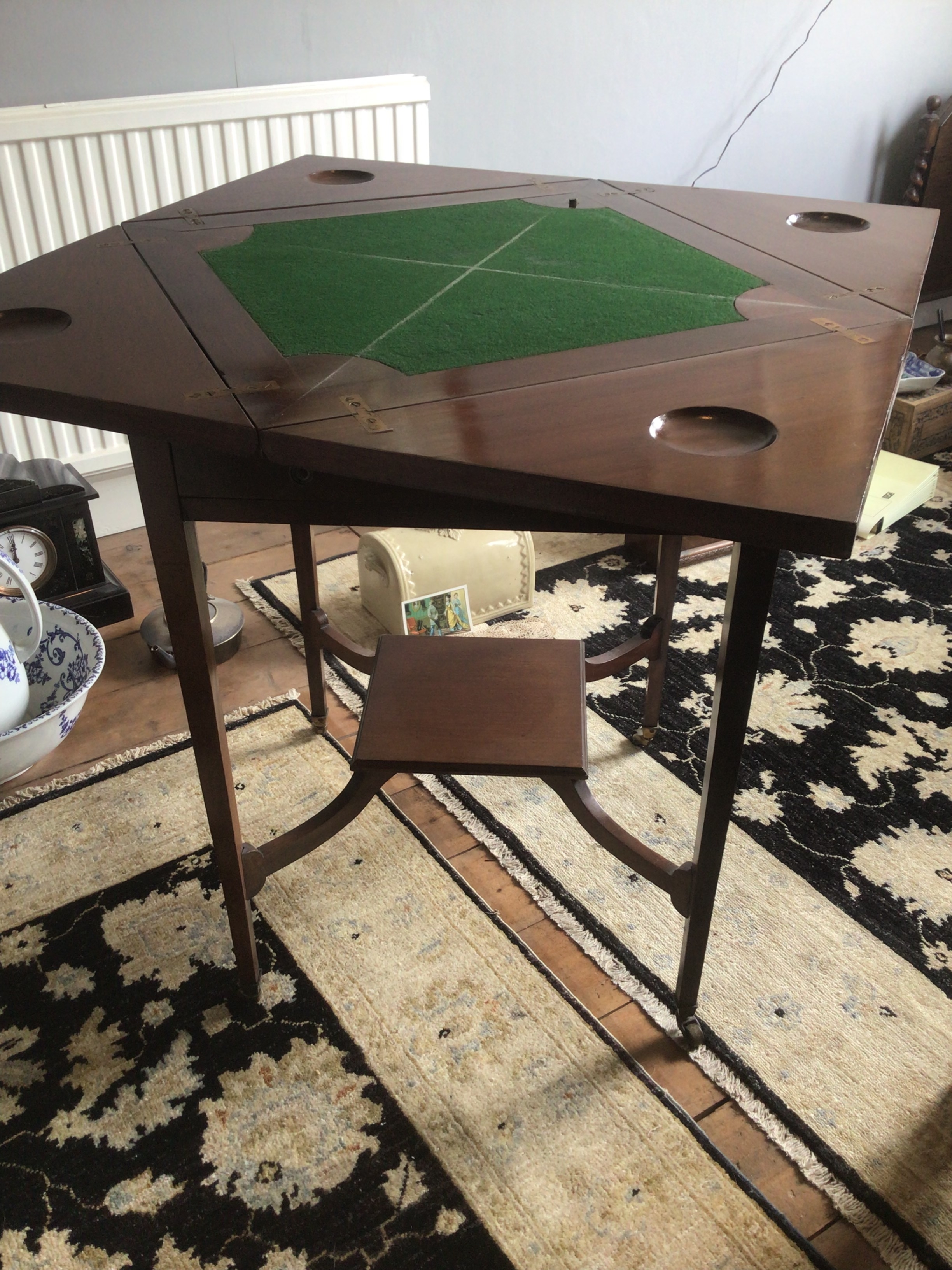  An Edwardian mahogany envelope card table with a quarterer top above a single drawer.  