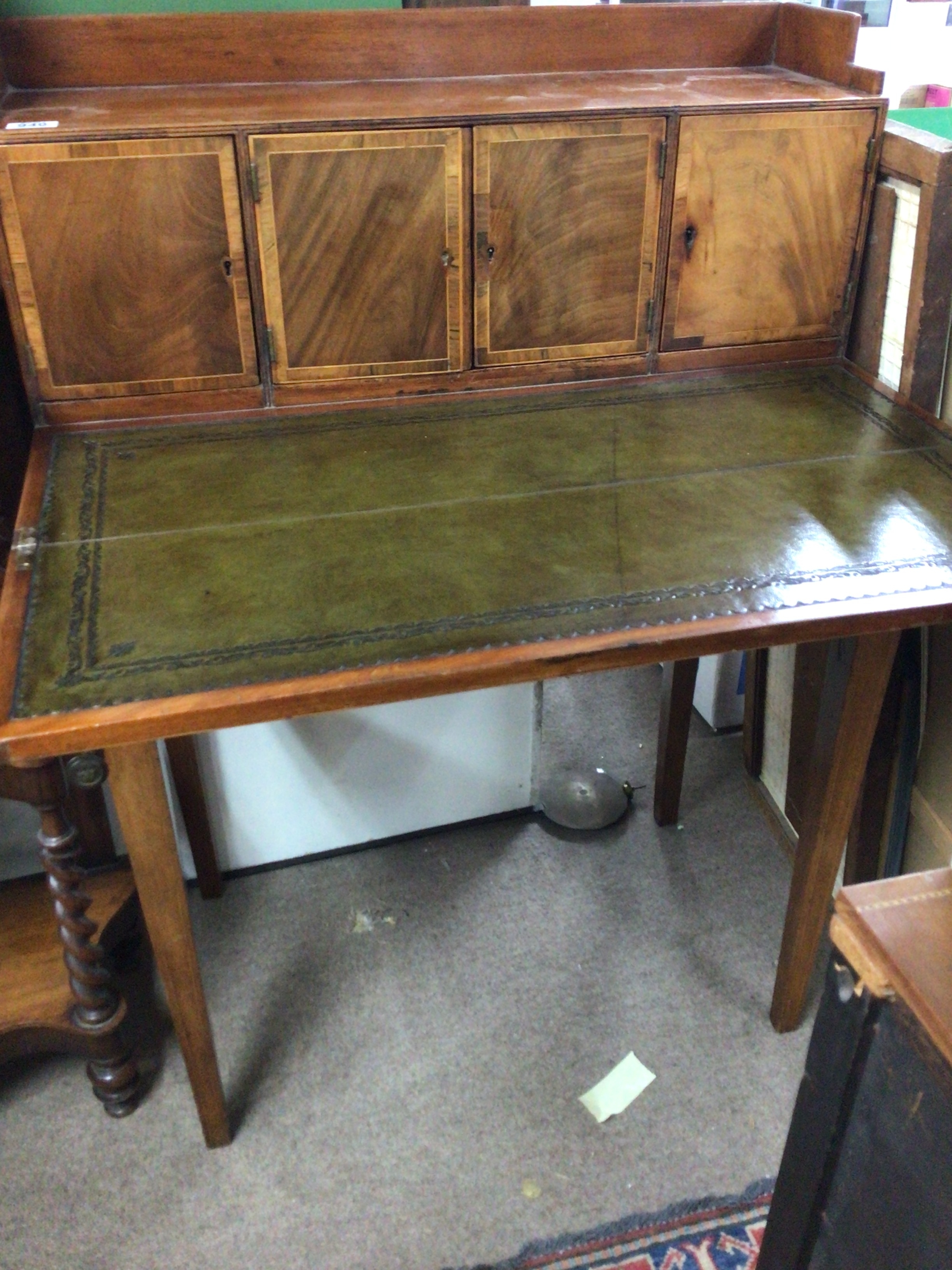 A 19th century mahogany and satinwood banded small desk with a raised back with cupboards above a hinged leather top with further drawers on square tapering legs.