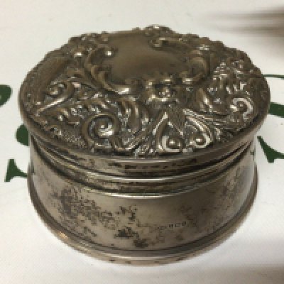 A Silver Jewellery box of circular shape Birmingham hallmarks with a Repousse chased hinged lid velvet lined.