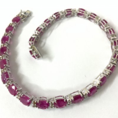 18ct white gold line bracelet set with oval rubies and RBC diamonds, with an open box clasp and double safety catch, boxed. Rubies 11.38ct. Diamonds 0.50ct. Postage category A