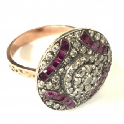 8ct rose gold art deco style round shaped dress ring set with step cut rubies and brilliant cut diamonds. Rubies 0.48ct approx. Diamonds 1.00ct approx. Approx ring size N/O. Postage category A