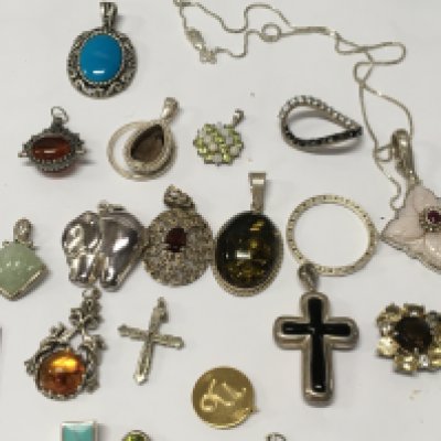 A collection of various silver pendants .