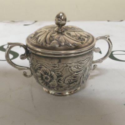 A small silver Porringer and cover with scroll handles repousse chased marks the base height 7cm weight 108g