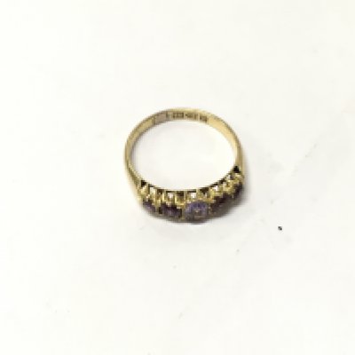 An 18ct gold five stone purple ring. Size O1/2, Approx weight 2.5grams.
