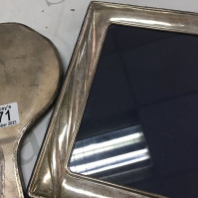 A silver hand mirror and a silver photo frame.