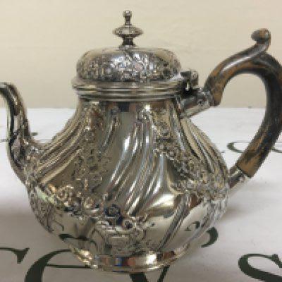 A Victorian silver tea pot with repousse chasing hinged lid marks to the base weight 378g