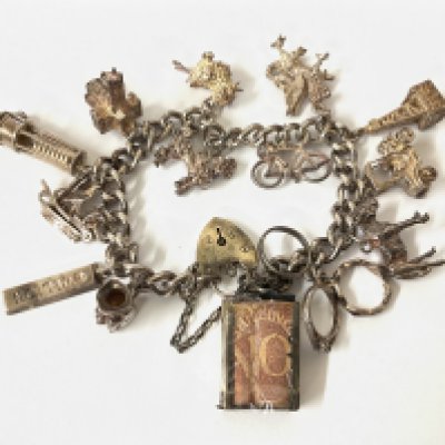 Silver charm bracelet with a shilling note charm. Postage category A