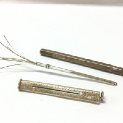 Two silver pencils and a silver swizzle stick. Postage category A