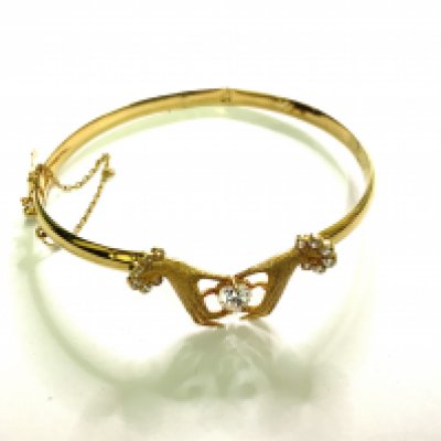 An unmarked high ct gold bangle inset with white stones, 7.8g. (A)